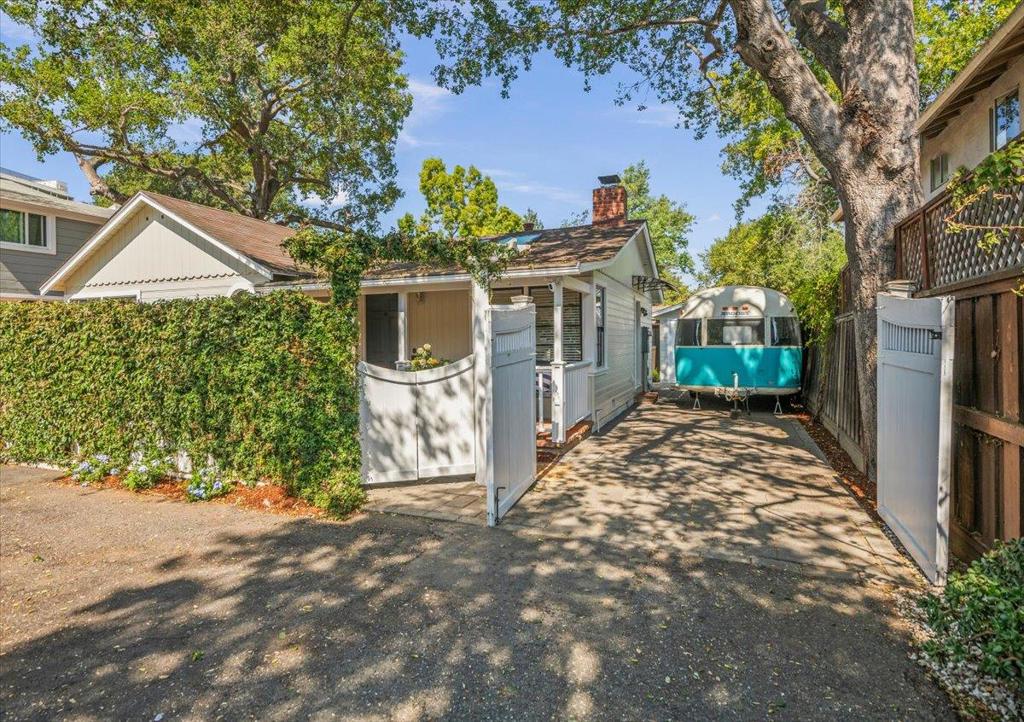 Beautiful expanded and updated 2 bed/ 2 bath one level home on a flag lot. Quiet and Peaceful. Away from the street. Professionally landscaped yard and gardens with automatic drip irrigation and dedicated vegetable boxes. Bricked covered front porch with attached bench swing and heater. Living room has 3 skylights, fireplace, high ceilings, and light & airy. Updated kitchen has stainless steel appliances--including gas stove top with hooded vent, double door refrigerator, dishwasher, wine refrigerator, breakfast bar/ cooking island, and skylights. Opens to updated dining room with 2 French doors leading to private sitting deck with cooling misters, 3 irrigated plantar boxes, and benches. Front bedroom has large closet with window. Private full bath off hallway. Primary bed / bath has Whirlpool tub & separate stall shower, double sinks. Bedroom also has double pane French doors leading to outside decking. House sq ft is 1173 per City stamp. Lot size is approximately 5200 sq ft with the driveway. Off the kitchen is a 1970 Vintage Airstream Argosy which owner used as a 3rd bedroom or office. It is not attached but close to the kitchen door. Garage/ work shop with kegerator and Craft beer tap on the wall. Laundry room with washer & dryer. Beautiful gardens and walkways.