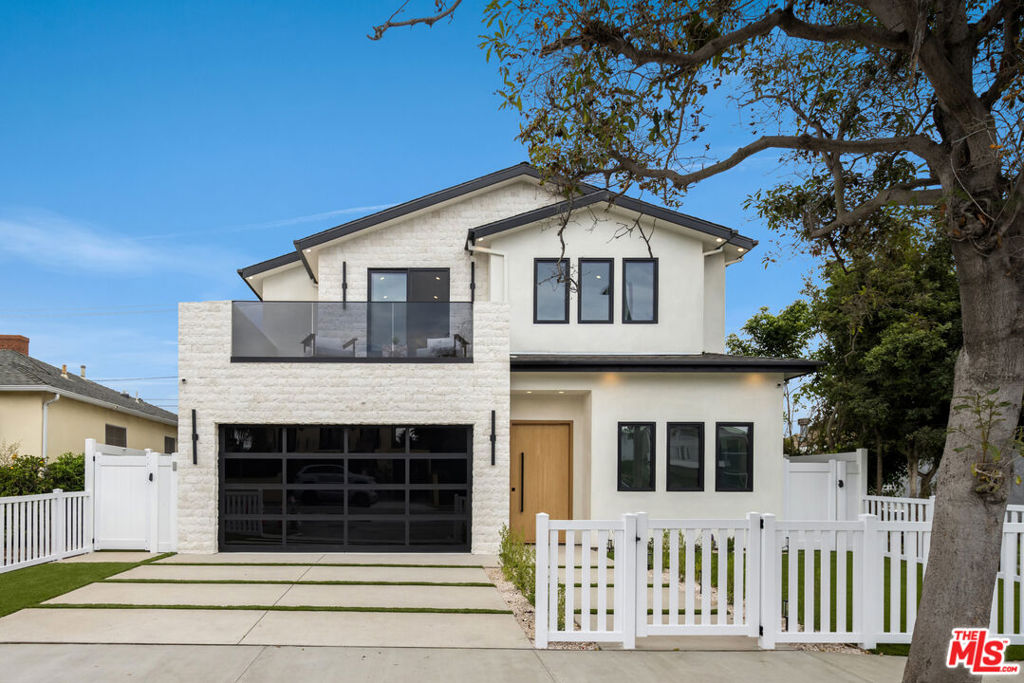 Welcome to one of Mar Vista's most refined new offerings, an architectural home that exemplifies California modern living with elevated design, premium finishes and effortless flow. Behind a crisp white fence and sculptural facade, this warm modern residence offers the perfect balance of privacy. Beyond the grand pivot door, a sun-drenched open floor plan unfolds. It is anchored by wide-plank French oak flooring, designer lighting and an airy atmosphere throughout. The first floor features expansive formal and casual living spaces that seamlessly connect to a chef's kitchen equipped with Thermador appliances, custom cabinetry and an expansive island designed for entertaining. The formal dining area is wrapped in natural wood paneling, adding texture and tone to the organic palette. Retractable walls of glass open to a lush private backyard with lounge seating and al fresco dining that invites true indoor-outdoor living. The second level features a spacious primary suite with vaulted ceilings, a spa-grade bathroom with a soaking tub and a private terrace overlooking the yard. Three additional en-suite bedrooms offer space and comfort for guests or family, each with refined finishes and generous proportions. Moments from Mar Vista's local boutiques, farmers markets and top-rated schools, this home represents a rare blend of architectural sophistication and relaxed SoCal living crafted for the most discerning buyer.