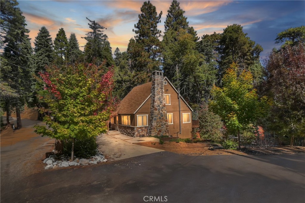 Take a look at this beautiful vintage cabin from 1935 with so many thoughtful upgrades! It sits on a corner lot and offers easy entry with only 2 small steps. Two bedrooms conveniently located on the main level, and the master bedroom upstairs is complete with a full bathroom and cozy sitting area. Breathtaking custom split granite wood burning fireplace with gas starter and arrowhead features demands to be the focal point of this room! Some of the many upgrades include electrical, water heater, plumbing and heating, as well as a Generac Generator for emergencies and a Lorax Ultra Surveillance system for peace of mind. Beautifully updated kitchen, with newer  appliances. Rustic T&G wood paneling enhances the cabin's charm. Lower level has an expansive open workshop/cellar type area, offering ample space and numerous possibilities. Outdoors you can get your fill of nature's beauty on this wrap-around deck or out on the gentle sloping yard. Easy access drive through style driveway with plenty of off-street parking. Additionally, the possibility of RV parking around the side, there's even a big wood or tool shed! This property is about an hour to Big Bear, and typically under 2 hours from LA, making it a fantastic commuter location. And of course, it is very close to many popular restaurants and shops in oh so popular Sky Forest..... home of LouEddie's Pizza. Minutes to historic Lake Arrowhead Village and the ever popular SkyPark at Santa's Village!