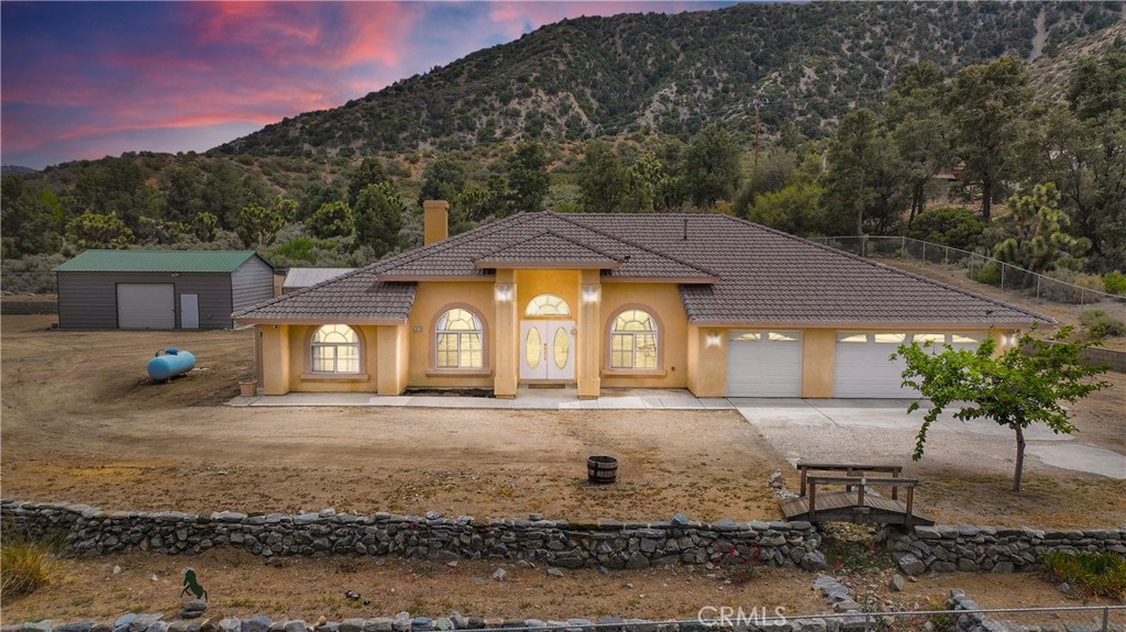 Discover the perfect blend of space, comfort, and mountain charm at 1679 Desert Front Rd in Wrightwood, CA. This well-maintained 4-bedroom, 3-bathroom home sits just outside Wrightwood proper on a paved road, and is being sold with the adjoining vacant lot—a rare opportunity to expand or simply enjoy extra room to roam.
Set against a stunning backdrop of mountain views, this property offers tall ceilings, generously sized bedrooms, and a spacious primary suite for ultimate relaxation. The 3-car garage is a unique find in this area, providing ample space for vehicles, gear, or workshop needs. This property also features a large greenhouse for all the plant lovers and a chicken coop!
Enjoy thoughtful rock landscaping throughout the fully fenced yard, complete with a remote-controlled gate for privacy and convenience. The property includes full RV hookups and a huge steel shed/storage building in the rear—perfect for equipment, hobbies, or extra storage.
Located just 8 miles from Mountain High Resort for winter fun, and only 1.5 hours from the beach for summer escapes, this home combines year-round adventure with everyday comfort. Central A/C keeps the home cool in warmer months, while mountain air and scenic views create a peaceful, retreat-like atmosphere.
Don’t miss your chance to own this versatile mountain property with room to grow!