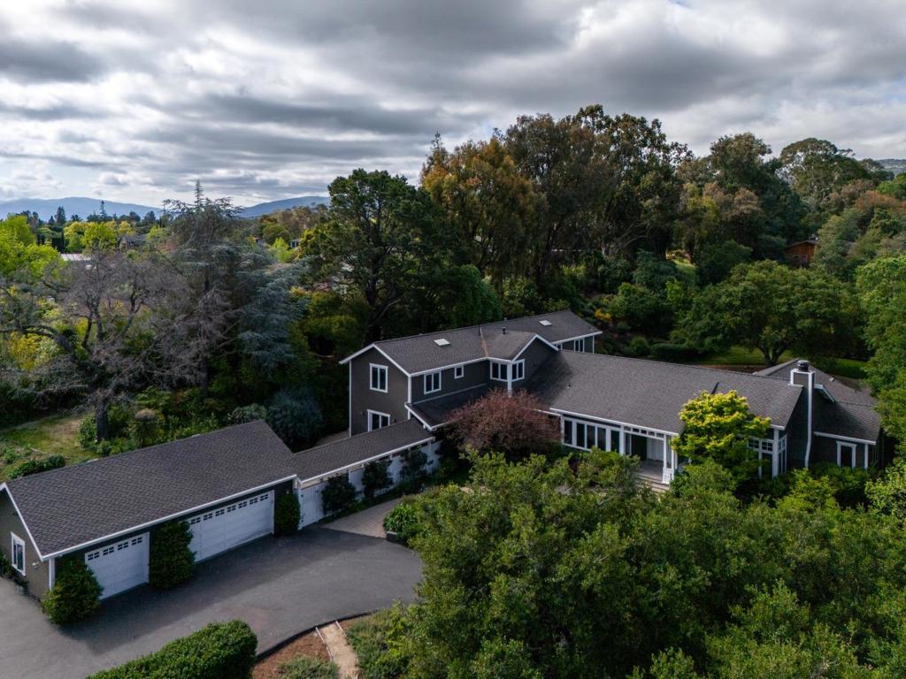 Deemed The Highland's most extraordinary home, this one-of-a-kind, five-star residence is set on 1.22 acres of park-like grounds with a pool and spa. The expansive floor plan is unified with beautifully refinished hardwood floors and fresh paint. Towering ceilings are defined with suspended trusses and pendant lights, while an entire wall of glass frames the rear grounds where a pool and spa await outdoor living. Fireplaces in the living room and family room have been newly renovated, as has the entire kitchen - a chef's dream enhanced by an additional catering kitchen and temperature-controlled wine cellar. This home offers versatile living spaces with 6 bedrooms, office, and 4.5 bathrooms. The primary suite and adjoining office plus additional bedroom are located on the main level, while four bedrooms are upstairs in their own wing. All around, the magnificent grounds invite entertaining and play with a vast level lawn, terraces, and a separate playground. The farm-to-table lifestyle also awaits with 12 raised vegetable beds in a fully enclosed area. All of this, plus minutes to shops and restaurants as well as access to highly acclaimed Cupertino schools.