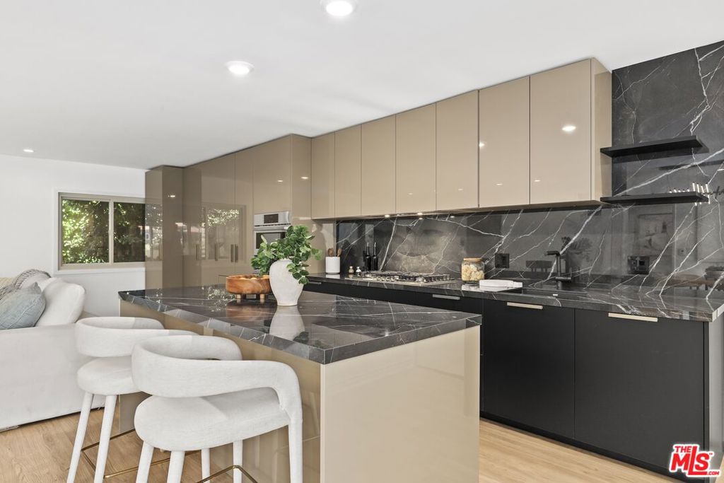 Welcome home to your Palm Springs like resort in the heart of West Hollywood. This beautifully renovated two-bedroom, two-bath residence features a reimagined Poggenpohl kitchen with new cabinets, appliances, countertop, backsplash, and a spacious kitchen island, complemented by a new Miele dishwasher and Bosch appliances. Brand new interior doors, new flooring, a new front door, upgraded recessed lighting throughout,  and remote operated custom made blinds elevate the home's modern appeal. The residence is further enhanced with a new Renewal by Andersen sliding door, and new windows and screens, filling the space with natural light. Positioned in the quiet rear of the complex, the living area and patio overlook the sparkling pool, while the primary bedroom offers a serene retreat tucked away for ultimate privacy. Just one block to Trader Joe's and the neighborhood pharmacy, and two blocks to Bristol Farms and Whole Foods, you'll enjoy unmatched convenience. Local favorites such as Laurel Hardware, Tu Madre, and Connie & Ted's are all just moments away, along with the vibrant restaurants and nightlife that define West Hollywood living. Set within a classic mid-century building, residents are welcomed by a striking terrazzo-tiled entry and can indulge in the resort-style pool and lounge area, complete with swaying palm trees, chaise lounges, and umbrellas, the perfect blend of style and relaxation.