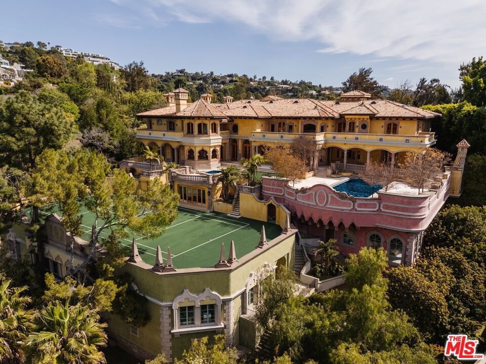 Set behind private gates on 1.7 acres in prime Holmby Hills, this nearly completed 34,450 SF estate is a triumph of European-inspired design and modern luxury. Crafted with hand-carved limestone, imported marble, and custom-milled white oak, it blends old-world artistry with state-of-the-art living. Highlights include a dramatic 34-ft coffered ceiling, grand marble staircase, 11 bedrooms (including 6 ensuite family rooms, 2 guest suites, and 3 staff quarters), and a stunning primary suite with panoramic views, spa baths, and rotunda lounge. The chef's kitchen features dual 8-ft marble islands and solid walnut cabinetry, while unique spaces like the Moroccan-inspired bar and under-pool art studio make this estate one-of-a-kind. Outdoors, enjoy a resort-style setting with a 50-ft pool and spa, limestone verandas, championship tennis court with clubhouse, and dedicated 40-car windowed garage and oversized motor court attached 6-car garage. Enterprise-grade low voltage system. Crestron smart home technology and complete fire sprinkler system with a 175 KVA generator. This global showpiece designed for grand entertaining and elevated daily living.