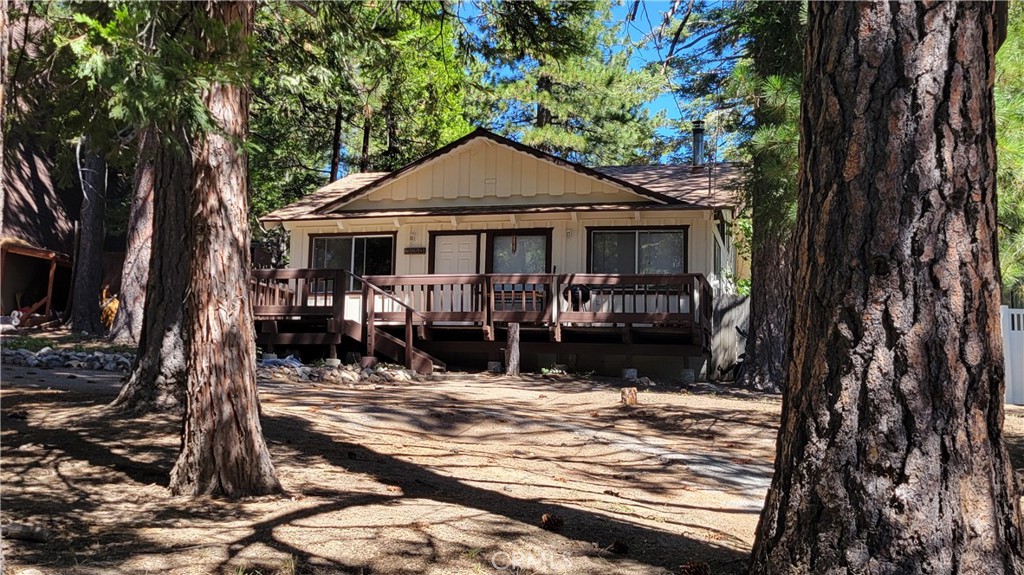 Fantastic new listing in Running Springs is ready for you! Large usable lot with front and back yards to enjoy features mature trees, lots of parking and a fence for pups or kids to play safely. Relax on the front porch or put a hammock up between the trees; this mountain get-away will be your refuge from the hectic world.
With a split level floor plan, the main living area occupies the lowest space and up just a few stairs are two bedrooms, a full bathroom, and a versatile bonus den/family room area. Vaulted ceilings and multiple windows make the cabin light and bright, while feeling like a cozy cabin in the woods. Upgrades like on-demand tankless water heater, newer roof, upgraded furnace, and a large Tuff Shed have been installed. Offered at a great value, be sure to include it on your next mountain tour!