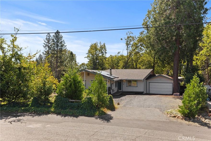 Welcome to this cozy survivor home on a quiet cul-de-sac in lower Magalia! Featuring OWNED solar with a backup battery and the neighboring .23 acre parcel included (totaling .46 acres). Any chef will appreciate the updated kitchen featuring alder cabinets, granite tile countertops, newer stainless steel appliances, and modern can lighting. The kitchen overlooks the family room containing a wood burning fireplace along with a sliding glass door that leads to the front deck. Down the hall is an additional storage closet, the indoor laundry room, the guest bedroom, and primary bedroom. The spacious primary suite features an attached bathroom containing a dual sink vanity with solid surface countertops and walk-in closet. A slider in the primary bedroom leads to a balcony, the perfect place for morning coffee. Off of the second living room is an additional bedroom/office/den as well as the perfect alcove to use as a home office or quiet sitting area with another slider leading to the back deck. Additional features include a whole house fan, attached 2 car garage, dual pane windows, storage shed, updated flooring in living areas, and plenty of room for RV parking.