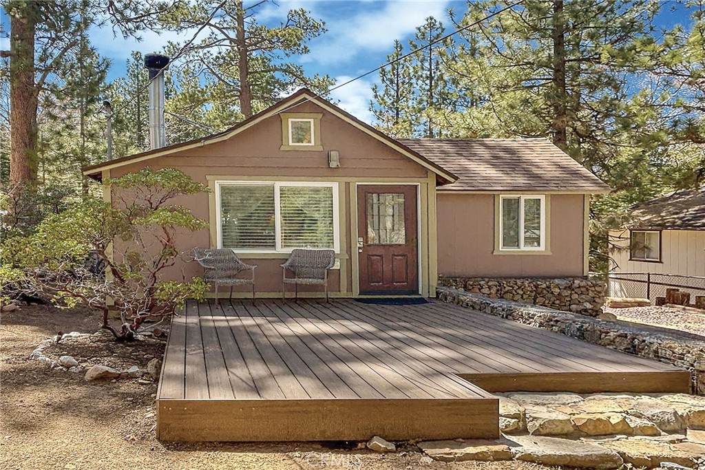 Welcome to your inviting mountain escape! Whether you're looking for a relaxing getaway or a high-performing investment opportunity, this beautifully updated 1-bedroom,1-bathroom cabin sits on a spectacular 9,650 sq ft lot amid mature plants & trees delivering a sense of quiet beauty. With over $71,000 in gross revenue for 2024 and $22,000 from January through April of this year, this owner-managed short-term rental has an impressive track record of success! Even better, the current owner is offering valuable mentorship during the transition, along with trusted contacts for cleaning, maintenance and insider knowledge to help you hit the ground running. Greeted with an open-concept living area where a stunning stone fireplace creates the ideal cozy centerpiece and soaring ceilings and abundant natural light add to the spacious, airy feel. The kitchen features modern updates including stainless steel appliances and has a seamless flow into the living space—great for whipping up a meal or relaxing after a day of adventure. Enjoy your morning coffee on the inviting composite front deck, surrounded by the natural beauty of pine, manzanita and flowering lilac plants that grace the front yard with color and charm. The generously sized bedroom boasts high ceilings, a pretty wood accent wall and plenty of light, while the bathroom offers a luxurious, spa-like experience with a custom-tiled shower and modern vanity. A tankless water heater and inside washer/dryer provide added convenience for guests and owners alike. Outside, enjoy the expansive fenced backyard with a large rear deck, relaxing spa, BBQ, and outdoor dining area—great for time spent gathering with friends, letting the pets roam and soaking in the mountain serenity this fantastic location delivers. Situated in a peaceful treed location just minutes from local mountain resorts, the National Forest, Big Bear Lake and the Village’s vibrant shops, restaurants and entertainment. Whether you’re a first-time investor or seasoned host, this turnkey property is your opportunity to own a piece of Big Bear’s magic—with the tools & resources for continued success as a thriving short term rental!