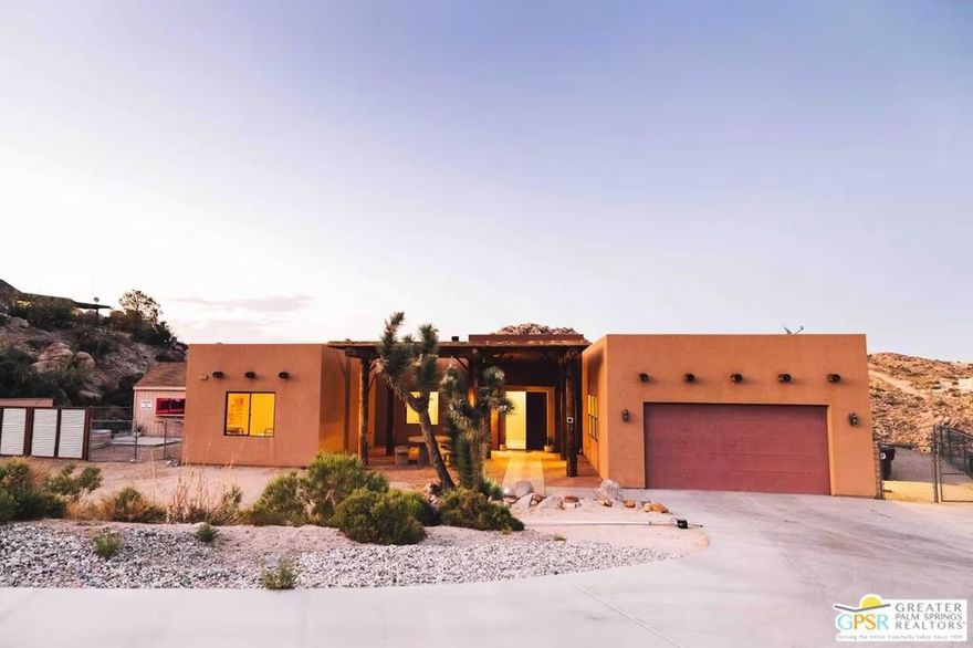 Stunning Santa Fe-Style Home in Western Hills Estates.  This custom-built 3-bedroom, 2-bath home sits on over an acre of land, surrounded by the iconic boulders of Western Hills Estates. Located just two minutes from downtown Yucca Valley and close to all the High Desert's attractions, this property offers both convenience and serenity. Inside, you'll find 10' high ceilings and an open-concept layout that seamlessly connects the kitchen and living room, creating a bright, airy space. The master suite features a cozy fireplace and en-suite bath, adding a touch of warmth and romance. Step outside to a backyard perfect for entertaining, complete with a built-in BBQ and outdoor fireplace, ideal for starry nights with friends or quiet evenings under the desert sky. The spacious side yard, with its dramatic boulders, offers endless possibilities for leisure spaces or a future pool. Don't miss this unique desert retreat schedule your tour today!