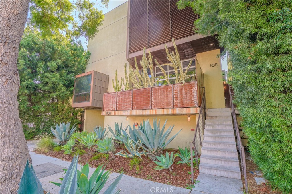West Hollywood living at its finest! Located in a highly sought after AIA Award-Winning Building, designed by prolific Architects Pugh-Scarpa! This modern architectural gem has been intricately designed to captivate the senses of any contemporary design enthusiast. Soaring 17-foot ceilings create an expansive, light-filled living space with effortless indoor-outdoor flow. The living space has polished concrete floors, large pocket windows, and a sliding metal-and-glass wall which opens to an oversized patio— complete with planter boxes, pergola, and high privacy fencing that is a perfect place for entertaining and relaxing. On the second level is a mezzanine-style office/flex space overlooks the living room, offering a dynamic and inspiring workspace. The top-floor primary suite features floor-to-ceiling windows with sweeping views of the Hollywood Hills. A flexible second room at the top level could potentially be used as a guest room, den, or studio. The spa-like primary bathroom includes a glass-tiled walk-in shower and tranquil ambiance. Other great features of the home include a Sub-Zero refrigerator, Dual Zone AC, and Ample storage throughout. Also includes gated subterranean parking and an HOA common area animal space/run at the back of the lot. All just moments from iconic Hollywood and L.A. landmarks—perfect for urban dwellers and design lovers alike.