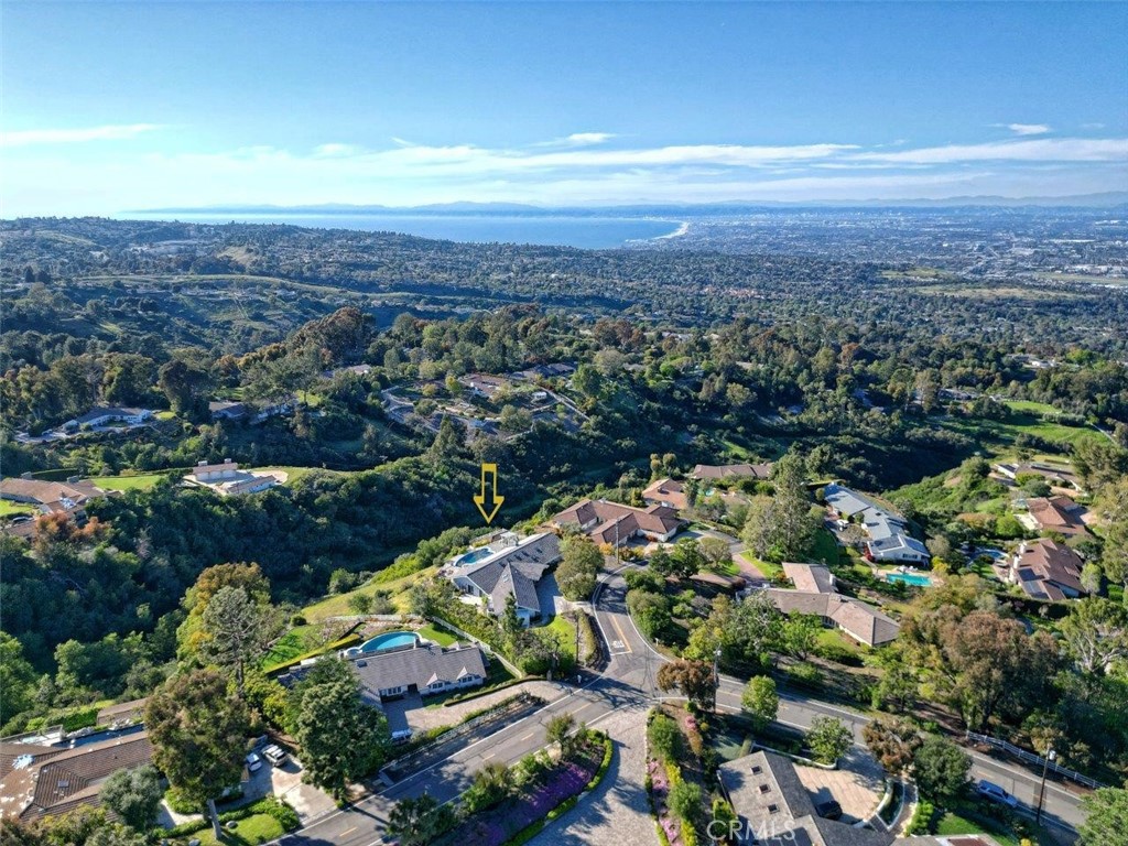 Nestled on a tranquil cul-de-sac in the exclusive 24/7 guard-gated enclave of Rolling Hills, this contemporary ranch-style masterpiece boasts unprecedented levels of luxury, space, and views of the ocean, Queen’s Necklace, Malibu coastline, nearby canyon, inspiring mountains, and sparkling city lights, including downtown Los Angeles, SoFi Stadium, and the iconic Hollywood sign. This single level residence surrounded by lush, manicured landscape was originally built in 1964 but taken down to the studs and rebuilt in 2020. The reimagined home boasts towering cathedral ceilings lined with skylights and high quality custom cabinetry, millwork, tile, and hardwood flooring throughout. It is also fitted with new plumbing, dual zone HVAC, energy efficient dual pane windows & sliding doors, electrical systems and roof. Step inside to discover a home lovingly designed to maximize beauty, ambiance, and light. The great room, which includes living, dining, and a towering library wall with rolling ladder, boasts a stunning wall of glass showcasing the breathtaking views. The open-concept kitchen sets the stage for your most daring culinary and entertainment adventures, featuring vaulted ceilings, quartz counters, chef-grade appliances, a huge central island, custom cabinetry as well as a walk-in pantry & wine fridge/bar counter nearby. The spacious primary suite showcases the best view and offers double walk-in closets and a beautiful spa-like bathroom. Meanwhile, there is one bedroom en-suite and one bedroom with direct access to the adjacent hallway bathroom. Two additional bedrooms share another hallway bathroom that exudes luxury and comfort. Outside, the entertainment space is surrounded by rose gardens, with multiple tiers of dining, sunning, and seating patios cascading down the backyard. The highlight is the 30' infinity-edge pool and spa finished with white marble, blue glass pebble bottom tiles & 4 waterfalls. It is complemented by an adjacent lounging area and a seating area with fireplace, perfect for relaxation and entertainment while overlooking the stunning views. This house has a 3-car garage with lots of space for storage, while a circular, paver driveway presents a grand entrance and plenty of guest parking. With direct access to hundreds of acres of horse trails and equestrian zoning, the property offers a lifetime of luxury living. This is a rare opportunity to make this dream home yours.