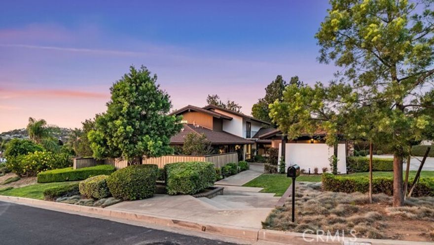 Welcome to 1411 Faren Drive, a custom Mid-Century Modern retreat in the hills of Lemon Heights where timeless design meets modern comfort. Walls of glass frame breathtaking city light views, filling 4,221 sq. ft. of living space with natural light and effortless indoor-outdoor flow. Recently refreshed with crisp new interior paint and sleek LED recessed lighting, the home feels both warm and contemporary— for today’s lifestyle. The flexible floor plan lives like a single story with 4 bedrooms and an executive office on the main level, while the entire upstairs is dedicated to a private primary suite with custom closets, spa-inspired baths, and its own living area. An oversized living room with soaring vaulted ceilings provides the perfect backdrop for grand entertaining, while the family room with entertainer’s bar invites relaxed gatherings with friends and loved ones. A formal dining room and 4 fireplaces further enhance the inviting ambiance. The chef’s kitchen is equipped with wood cabinetry, granite counters, stainless appliances, eating bar, and an inviting informal dining area. A convenient laundry and storage room is nestled behind the kitchen. Nearly every room opens to the outdoors, where multiple patios and a low-maintenance grass backyard with drought-tolerant gardens create the ideal setting for peaceful mornings, vibrant sunsets, and sparkling city-light views. All of this is within the award-winning Tustin school boundaries — Arroyo Elementary, Hewes Middle, and Foothill High — in a highly sought-after area where homes rarely become available. This home is a sanctuary of light, space, and thoughtful design in one of North Tustin’s most coveted areas.