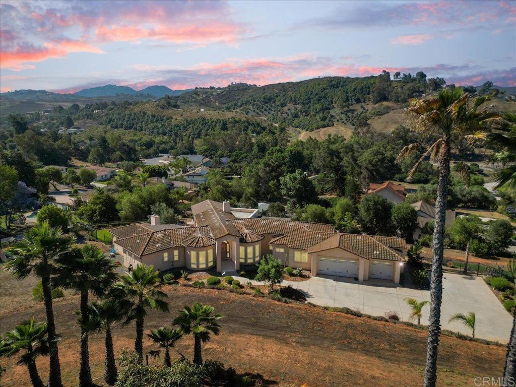 Looking for a home that’s anything but ordinary? This fully custom, single-story home, built in 2007, delivers thoughtful design, modern upgrades, and wide-open space — all set behind a gated entry with rolling foothill and treetop views. Step inside this 3 bedroom home with an optional 4th bedroom or hobby room, and you’ll immediately notice the vaulted ceilings to the seamless blend of sleek engineered wood and tile flooring throughout. The updated kitchen is equipped with a electric induction cooktop, new dishwasher and microwave, trash compactor, quartz countertops, built-in refrigerator and a spacious walk-in pantry. Expansive south-facing windows flood the main living areas with natural light highlighting an open, entertainer-friendly layout ideal for gatherings of any size. The primary bath has been beautifully updated with fresh custom tile, quartz counters, and a never-used soaker tub. Designed with privacy and function in mind, each side of the bath lives like its own private space with separate vanities, separate toilets, and individual access. Both sides connect through a unique, custom-designed curbless walk-in shower and a spacious, double-sided walk-in closet. Other home features include refreshed guest baths -- the powder bath has been updated with stylish new tile and quartz counters, while the hall bath offers new quartz counters, and upgraded sink and fixtures, and a new frameless shower door. Smart thermostats control the dual-zone home HVAC system, keeping the home comfortable year-round, while the recently certified interior sprinkler system provides added peace of mind. The oversized kitchen island invites casual meals, morning coffee, evening cocktails or enough space for your holiday cookie making. And with cozy fireplaces in both the living room and primary suite, you’ll always feel right at home. A separate full guest wing provides privacy for visitors and includes a convenient interior laundry area. The oversized 3-car garage offers plenty of room for vehicles, tools, and those projects you keep meaning to tackle. Fully OWNED SOLAR (18 panels) keeps true-up bills low (typically just $350–$400 per year) so you can enjoy guilt-free A/C all summer long. Outside, the beautifully landscaped, mostly drought-tolerant grounds stretch across more than 2 acres offering endless flexibility for outdoor living and entertaining. The expansive 3,000 sqft paver patio, complete with a built-in propane BBQ and firepit, easily accommodates gatherings of 80–100 guests, with plenty of on-site space for parking to match. Mature fruitless olive trees, rolling green views, and thoughtful hardscaping create a space that feels both relaxed and refined. Whether you’re hosting a weekend brunch, a casual cookout, or a large celebration under the stars, this yard adapts to your lifestyle. The property also includes a rolling gated dog run, two sheds, and extra parking for guests, toys, or RVs plus room to add an ADU, pickleball court, or pool to truly make it your own. Additional highlights include an extended covered patio thoughtfully added by the sellers to create a larger, more comfortable space for year-round outdoor living, along with custom wrought iron fencing and a privacy driveway gate. With its custom design, smart upgrades, and a sprawling lot full of potential, this home delivers the perfect blend of comfort, style, and flexibility. Whether you’re entertaining, hosting guests, or simply enjoying the views, life here just gets better.
