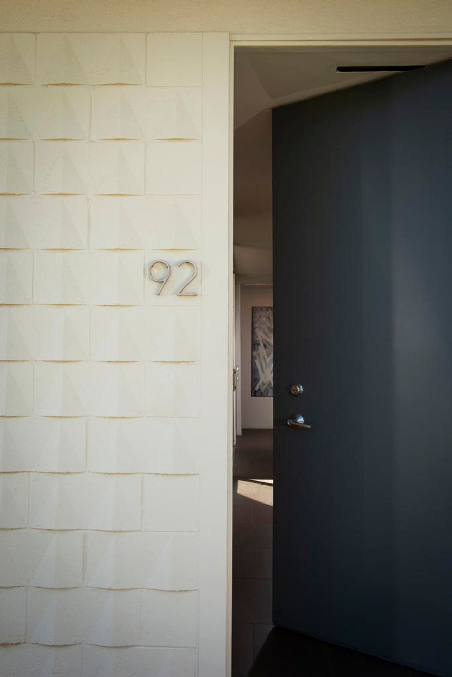 Situated in a prime location with sweeping triple fairway views, this mid-century gem, originally designed by renowned modernist Richard Harrison, was reimagined by noted architect Robert Kleinschmidt.  Featured in Palm Springs Life and Interior Design magazine, the home epitomizes desert sophistication. Step into a sun-drenched space, where natural light pours in through a dramatic linear skylight that stretches across the living room. A custom cantilevered rosewood credenza thoughtfully divides the living and dining areas, adding a touch of artistry. Each room seamlessly connects to the outdoors, with floor-to-ceiling sliders that open onto either a serene private patio or a lush inner courtyard. The home's porcelain tile, laid in a striking ashlar bond pattern, exudes contemporary elegance while flowing effortlessly from interior spaces to exterior tranquility, creating a harmonious connection to the surrounding landscape. At the heart of the home, a modern chef's kitchen awaits, outfitted with premium Miele and Fisher & Paykel appliances, custom wooden cabinetry and sleek new quartz countertops--an ideal space for culinary creativity. New ceiling fans and discreet HVAC diffusers ensure optimal comfort in every room. Both spacious bedrooms feature lacquered cabinetry, built-in shelving, and ample closet storage, offering a blend of practicality and style. An EV charger is conveniently included in your carport. Plus, your pool escape and clubhouse are just nearby. Past the 24-hour guarded gate, 'The Gem of the Desert' offers a unique elevated lifestyle with its Ted Robinson-designed 18-hole executive golf course, 15 pools and spas. The lively William Cody designed clubhouse is waiting to welcome you to its formal dining room, casual cocktail lounge and a terrace overlooking the famous Seven Lakes fountain. Welcome home!