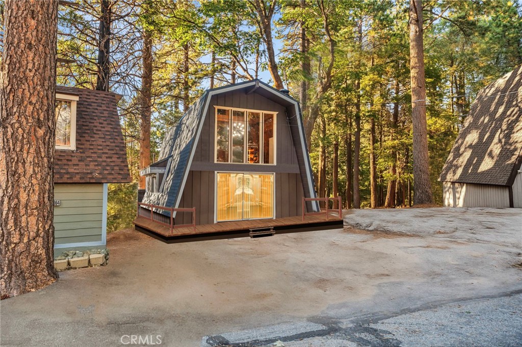 Tucked on a quiet street in Running Springs, this classic gambrel cabin pairs easy access with true mountain charm. A near-level approach and level parking make arrivals simple. Inside, the main level places the living room around a wood-burning fireplace, with high ceilings that open to a roomy loft. The floor plan is effortless: a bedroom and full bath on the entry level, plus an eat-in kitchen and laundry closet; the loft above flexes as a second bedroom, office, or lounge. A deck off the living area looks out to the pines—perfect for coffee at sunrise or starry evenings after the slopes. Minutes to village shops and dining, with quick connections to Hwy-18 for commuter ease, and close to Snow Valley, Lake Arrowhead, and miles of San Bernardino National Forest trails. A straightforward, well-kept retreat that lives comfortably today and welcomes your personal touch tomorrow.