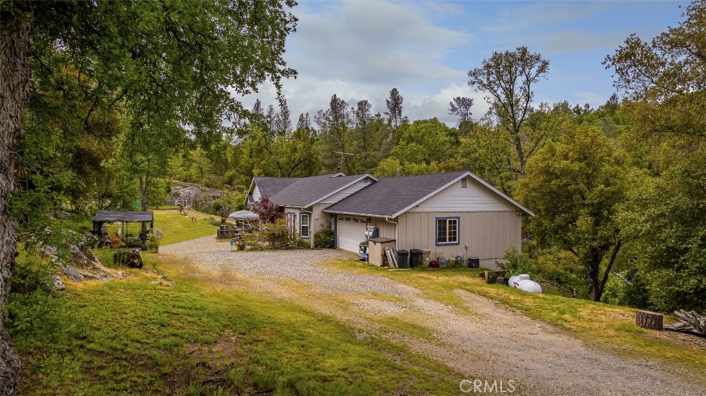 If you are searching for a little seclusion, this home will give you that feeling whether you are relaxing inside or out on your back deck taking in nature, or just working around your yard. Unbelievable peaceful setting, all while being relatively close to town, Bass Lake and Yosemite Nation Park and near the end of the road, makes the seclusion so much more delightful. Once inside, you will notice the brightness from the many windows and the open space of the living room that easily blends with the dining room. Once you pass the spacious kitchen, you will be amazed to find the large family/den area that you can just use your imagination of what you would like to do with this room, and all while having an attached bathroom and exit doors for ease of entry. Beyond the garage, there is more space that can be used as a music studio, arts and crafts room or another bedroom with a large walk-in closet for that older child or guests. There is plenty of room for storage under the house with high ceilings to place your kayaks, bikes and/or toys. Come and see for your self! Enjoy the front patio area views or the back deck overlooking the lovely property!