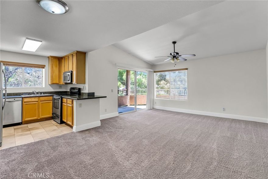 Light and airy with views of the surrounding hills and city lights, this top floor, end unit condo in the Sage Canyon community has been recently refreshed with new carpet and paint throughout.  The travertine tile entry transitions to the family room with vaulted ceilings, abundant natural light, and ample space for furnishings.  The wrap around balcony with views of the surrounding hills and city lights effectively expands the living space of the family room.  Adjacent to the family room is the upgraded kitchen with granite counter tops, stainless-steel appliances, and plenty of cabinetry.  The primary bedroom also shares views of the surrounding hills and boasts a generous walk-in closet.  A full bath enhanced with granite counter tops, bypass glass shower doors, and ceramic tile, completes the floor plan.   In-unit laundry contributes additional convenience.  Outdoor amenities include the community pool; a great place to cool off on hot day, and Sierra Bella Park is walking distance away.   Located conveniently close to the 91, 241, and 15 freeways, shopping and local schools.