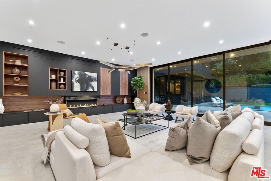 Fully furnished and turnkey!  Exhibit your sense of style in this fashionably designed and impeccably appointed, modern 5 bedroom Beverly Hills entertainer's dream. Step past the gates and front door into the open plan living space with its large gourmet kitchen, formal dining area and great room. The kitchen features a large island with multiple seating areas and custom cabinetry. The formal dining area is trimmed with a hardwood ceiling and large glass storage wall. The great room includes a fireplace, cabinet wall, modern chandelier, and nearly full width floor to ceiling retractable glass wall for whole house access to the rear deck and copious amounts of natural light. The main level outdoor deck includes multiple seating areas, a large pool and spa, lush privacy landscaping, and lawn with its seamless connection to the living areas make an impressively large indoor outdoor entertaining area. The entire living space is dynamically furnished and trimmed in black and natural wood, a theme that carries over to the outside of the detached ADU guest house. The upper level features four guest rooms, highlighted by the sparkling primary suite with its large walk-in closet with custom shelving, and spa-like bath with dual basins and large walk-in wet area with multiple shower heads and soaking tub behind glass. A 180-degree wrap around balcony and garage-top deck add outdoor lounge amenities to the upper level. A 2 story guest house includes a kitchenette, living area, and powder room on the main floor and sleeping chamber, bath, and office on the upper level, which can be converted into a 6th bedroom. Newly remodeled ground up and ideally situated in the exclusive Trousdale Estates enclave, you will be minutes away from the Golden Triangle and West Hollywood and all the best dining, shopping, and entertainment the city has to offer
