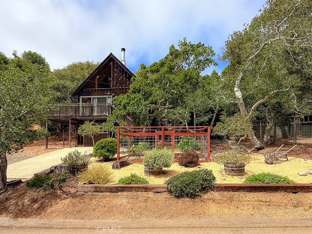 Charming Chalet with Custom Remodel Plans plus Ocean and Forest Views!! Perched on a quiet street directly across from Rancho Marino Reserve, this unique 2 bedroom 2 bath offers stunning, uninterrupted views of the ocean and forest on a 10,000 square foot lot and a deck to enjoy the serene beauty of nature with deer, wild turkeys, quail, and other wooded creatures. Nestled among stately oaks, the chalet-style home features a private garden patio, a wrap-around deck and an automated sprinkler system, creating a peaceful and wildlife-rich setting. The home comes with plans for a complete remodel, with permit approval expected any day—saving significant time, expense and effort. The three-level layout includes an oversized garage with bathroom on the first level, a kitchen, bath, living area, and bedroom on the second level, and on the third - a sleeping loft with knotty pine vaulted ceilings. Recent upgrades include a custom wood-burning fireplace with green-start igniter and a whole-house water filtration system. Additional features include a fully insulated, detached studio with Milgard windows and Hardie shingle siding. The property also offers a 1,000-gallon rainwater cistern to nourish fruit trees, a 220v/50a EV charging plug, RV parking with ocean views, and a Vacation Rental License, making this a rare combination of privacy, natural beauty, and income potential.