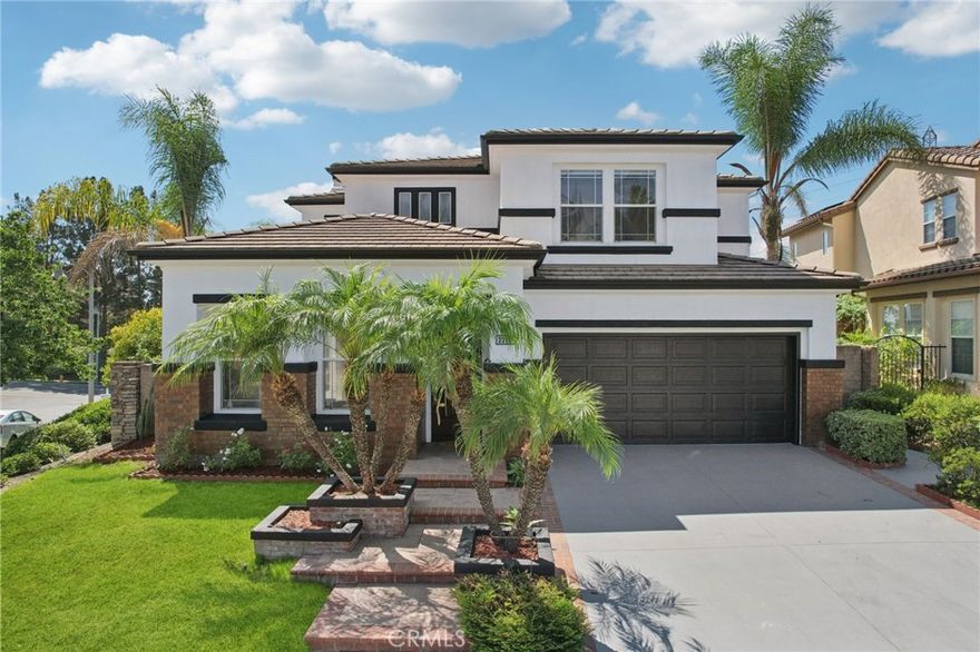 Discover the perfect blend of elegance and comfort in this stunning two-story residence, ideally situated on a premier corner lot at the end of a tranquil cul-de-sac. This is more than just a home; it’s a lifestyle, with a lovely community park and playground just a short stroll away and breathtaking views of the surrounding hills and Saddleback Mountain. Step inside and be captivated by a dramatic two-story foyer, where a graceful curved staircase is accented by a cascading crystal chandelier. The sun-drenched, open-concept floor plan flows effortlessly, guiding you to the heart of the home: a spectacular gourmet kitchen. An entertainer’s dream, this space has been beautifully updated with gleaming white quartz countertops, a full-height backsplash, a large center island with a cooktop, and stainless steel double ovens. With a built-in planning desk, a breakfast bar, and extensive pantry storage, this kitchen is as functional as it is beautiful. It opens directly to the inviting family room, where a cozy brick fireplace creates a warm focal point for gatherings. This home’s thoughtful layout offers incredible flexibility, including a formal dining room with French doors to a side patio and a desirable main-floor bedroom, perfect for guests, in-laws, or a private home office. Upstairs, a spacious and versatile loft provides a wonderful bonus area for a media room, playroom, or second office. Your private retreat awaits in the expansive primary suite, a serene sanctuary with stunning canyon and mountain views. This luxurious space boasts a chic, custom-designed slatted wood accent wall, dual walk-in closets, and a large en-suite bathroom complete with a soaking tub and separate walk-in shower. The secondary bedrooms are generously sized and share stylishly updated bathrooms featuring modern backlit LED mirrors and designer fixtures. The living space extends seamlessly into the entertainer's backyard, a private oasis with no homes directly behind. An expansive paver patio offers multiple zones for dining and lounging, all beautifully shaded by an oversized pergola—the perfect setting for year-round enjoyment. As a resident, you will enjoy exclusive access to the famed Lake Mission Viejo for boating, private beaches, summer concerts, and more. Zoned for the highly-acclaimed Capistrano Unified School District, this exceptional property has it all. Your new lifestyle awaits!