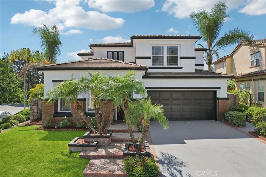 Discover the perfect blend of elegance and comfort in this stunning two-story residence, ideally situated on a premier corner lot at the end of a tranquil cul-de-sac. This is more than just a home; it’s a lifestyle, with a lovely community park and playground just a short stroll away and breathtaking views of the surrounding hills and Saddleback Mountain. Step inside and be captivated by a dramatic two-story foyer, where a graceful curved staircase is accented by a cascading crystal chandelier. The sun-drenched, open-concept floor plan flows effortlessly, guiding you to the heart of the home: a spectacular gourmet kitchen. An entertainer’s dream, this space has been beautifully updated with gleaming white quartz countertops, a full-height backsplash, a large center island with a cooktop, and stainless steel double ovens. With a built-in planning desk, a breakfast bar, and extensive pantry storage, this kitchen is as functional as it is beautiful. It opens directly to the inviting family room, where a cozy brick fireplace creates a warm focal point for gatherings. This home’s thoughtful layout offers incredible flexibility, including a formal dining room with French doors to a side patio and a desirable main-floor bedroom, perfect for guests, in-laws, or a private home office. Upstairs, a spacious and versatile loft provides a wonderful bonus area for a media room, playroom, or second office. Your private retreat awaits in the expansive primary suite, a serene sanctuary with stunning canyon and mountain views. This luxurious space boasts a chic, custom-designed slatted wood accent wall, dual walk-in closets, and a large en-suite bathroom complete with a soaking tub and separate walk-in shower. The secondary bedrooms are generously sized and share stylishly updated bathrooms featuring modern backlit LED mirrors and designer fixtures. The living space extends seamlessly into the entertainer's backyard, a private oasis with no homes directly behind. An expansive paver patio offers multiple zones for dining and lounging, all beautifully shaded by an oversized pergola—the perfect setting for year-round enjoyment. As a resident, you will enjoy exclusive access to the famed Lake Mission Viejo for boating, private beaches, summer concerts, and more. Zoned for the highly-acclaimed Capistrano Unified School District, this exceptional property has it all. Your new lifestyle awaits!