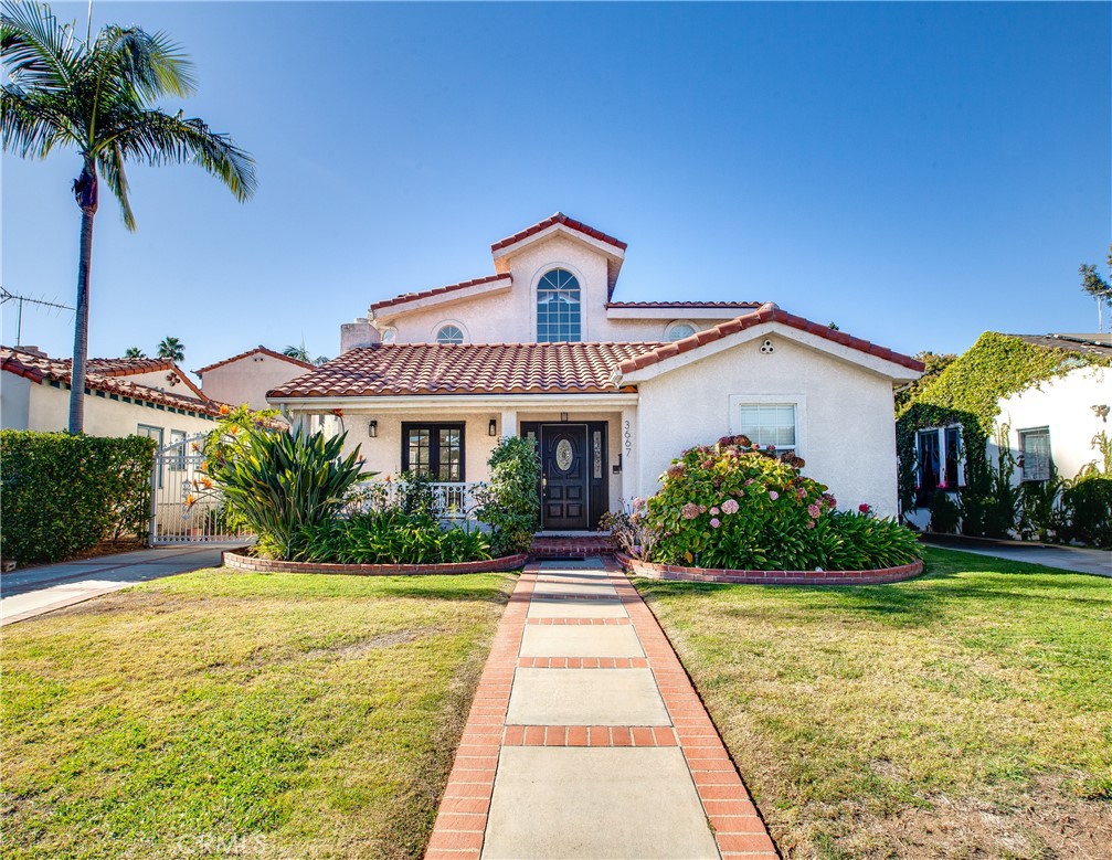 Welcome to an unparalleled sanctuary in Mar Vista, where timeless elegance meets modern convenience. This rare offering includes a sprawling 5 bedroom, 4 bathroom single family retreat set on 2 contiguous lots, delivering abundant space both inside & out. You will be greeted home by enchanting flower beds, arched windows & a Spanish tile roof evoking Hollywood glamour. Step inside to a seamless flow of living space with oversized neutral tile floors & crisp white walls as a versatile backdrop for your style. The inviting living room features a cozy fireplace & French doors to an enclosed front patio. Adjacent to the living room, the formal dining area offers ease of entertaining with direct kitchen access. The kitchen is a culinary delight, boasting white cabinetry, granite slab countertops, recessed lighting & stainless steel appliances, including double ovens. A peninsula connects the casual breakfast nook which flows into a spacious family room bathed in natural light by a wall of windows & sliding door to the backyard. A convenient half bath & separate laundry room complete the living space. The main level also includes 2 versatile bedrooms sharing a full bathroom, ideal for guests, multi-generational living, or home offices. Ascend the grand staircase to the second floor, where cathedral ceilings & natural light create an airy atmosphere. 2 additional secondary bedrooms share a well-appointed bathroom. Your luxurious primary suite features vaulted ceilings, a private balcony for your morning coffee, dual closets & a 5 piece ensuite with dual sinks & an oversized soaking tub. Step outside to your private paradise, where a generous patio & lush grassy area provide endless opportunities for outdoor enjoyment. The included second lot offers incredible potential for an accessory dwelling unit (ADU) while preserving the compound-like ambiance. A gated driveway leads to a detached 2 car garage, further enhancing the privacy & functionality. Located moments from the Mar Vista Recreation Center, highly rated schools, vibrant restaurants & boutiques of Venice & Santa Monica, this home is positioned for the best of Westside living. With proximity to Century City, Beverly Hills, Downtown LA & LAX, it is perfect for those seeking tranquility along with accessibility. Lovingly maintained by the same family for over 30 years, this exceptional property is ready to begin its next chapter. Make it yours this holiday season & create cherished memories for years to come.