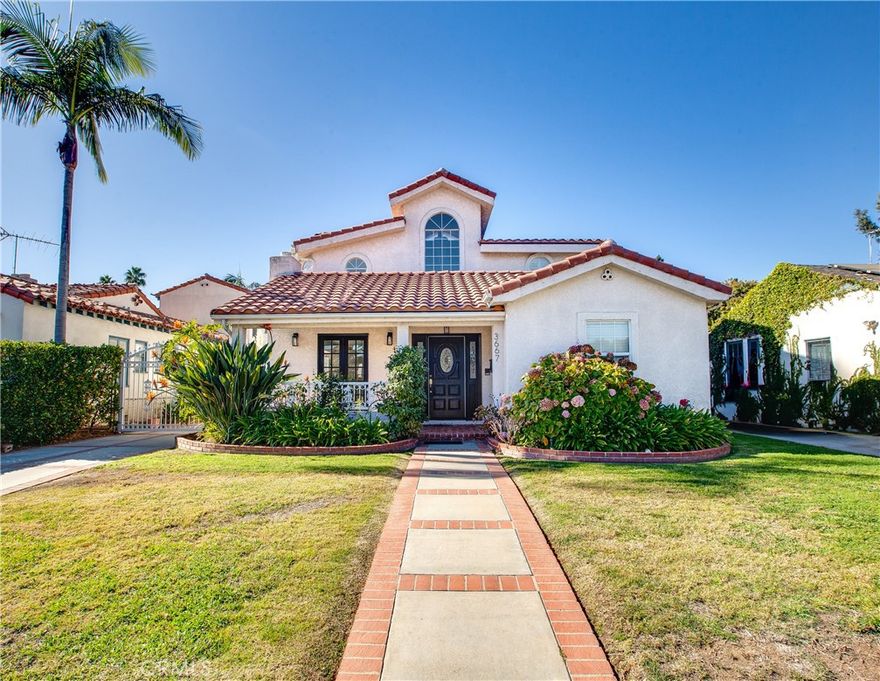 Welcome to an unparalleled sanctuary in Mar Vista, where timeless elegance meets modern convenience. This rare offering includes a sprawling 5 bedroom, 4 bathroom single family retreat set on 2 contiguous lots, delivering abundant space both inside & out. You will be greeted home by enchanting flower beds, arched windows & a Spanish tile roof evoking Hollywood glamour. Step inside to a seamless flow of living space with oversized neutral tile floors & crisp white walls as a versatile backdrop for your style. The inviting living room features a cozy fireplace & French doors to an enclosed front patio. Adjacent to the living room, the formal dining area offers ease of entertaining with direct kitchen access. The kitchen is a culinary delight, boasting white cabinetry, granite slab countertops, recessed lighting & stainless steel appliances, including double ovens. A peninsula connects the casual breakfast nook which flows into a spacious family room bathed in natural light by a wall of windows & sliding door to the backyard. A convenient half bath & separate laundry room complete the living space. The main level also includes 2 versatile bedrooms sharing a full bathroom, ideal for guests, multi-generational living, or home offices. Ascend the grand staircase to the second floor, where cathedral ceilings & natural light create an airy atmosphere. 2 additional secondary bedrooms share a well-appointed bathroom. Your luxurious primary suite features vaulted ceilings, a private balcony for your morning coffee, dual closets & a 5 piece ensuite with dual sinks & an oversized soaking tub. Step outside to your private paradise, where a generous patio & lush grassy area provide endless opportunities for outdoor enjoyment. The included second lot offers incredible potential for an accessory dwelling unit (ADU) while preserving the compound-like ambiance. A gated driveway leads to a detached 2 car garage, further enhancing the privacy & functionality. Located moments from the Mar Vista Recreation Center, highly rated schools, vibrant restaurants & boutiques of Venice & Santa Monica, this home is positioned for the best of Westside living. With proximity to Century City, Beverly Hills, Downtown LA & LAX, it is perfect for those seeking tranquility along with accessibility. Lovingly maintained by the same family for over 30 years, this exceptional property is ready to begin its next chapter. Make it yours this holiday season & create cherished memories for years to come.