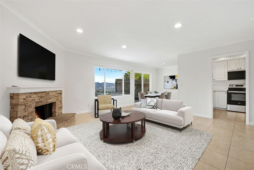 This pet-friendly, single-level 2-bedroom, 2-bathroom corner unit is a rare find offering a spacious enclosed yard, sweeping mountain views, and the convenience of all hard-surface flooring with no carpet! Just minutes from Dana Point Harbor, this 900-square-foot home features an open-concept layout with a modern kitchen, quartz countertops, a newer microwave, and stove. The primary suite includes two closets and plenty of natural light. The living room is warm and inviting with recessed lighting, a stacked brick gas fireplace, and sliding doors leading to the yard. Additional conveniences include washer & dryer hookups, a one-car garage, and one assigned parking space.