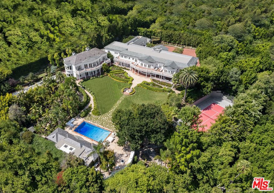Indulge in luxury living at the Azria Estate, a gorgeous Los Angeles mansion located in the Holmby Hills neighborhood known for some of the most historic and iconic estates in the city. Designed by legendary architect Paul Williams, this luxurious property merges colonial architecture with modern amenities, resulting in a chic and timeless experience. This world-class property offers the utmost privacy and is set behind a long, gated driveway, providing security and peace of mind. The main house offers ample space for entertaining inside and outwith a catering kitchen and infinity pool with its own sauna. A separate 5,500-square-foot building hosts a theater, game room, and stunning home office. All 14 bedrooms have thoughtful and elegant design. The entire mansion plays host to a modern atmosphere with bright, airy colors and warm wood floors. The beautifully manicured grounds include rolling lawns, mature trees, a tennis court, a lush Japanese and Mediterranean Garden, and a greenhouse for growing produce. This home is the epitome of entertainment, where large get-togethers, movie screenings, high-scale fashion events, and charity galas seamlessly unfold, making every occasion an unforgettable experience. This distinguished estate is the height of elegance and privacy, with a flawless layout perfect for family, staff, and guests.