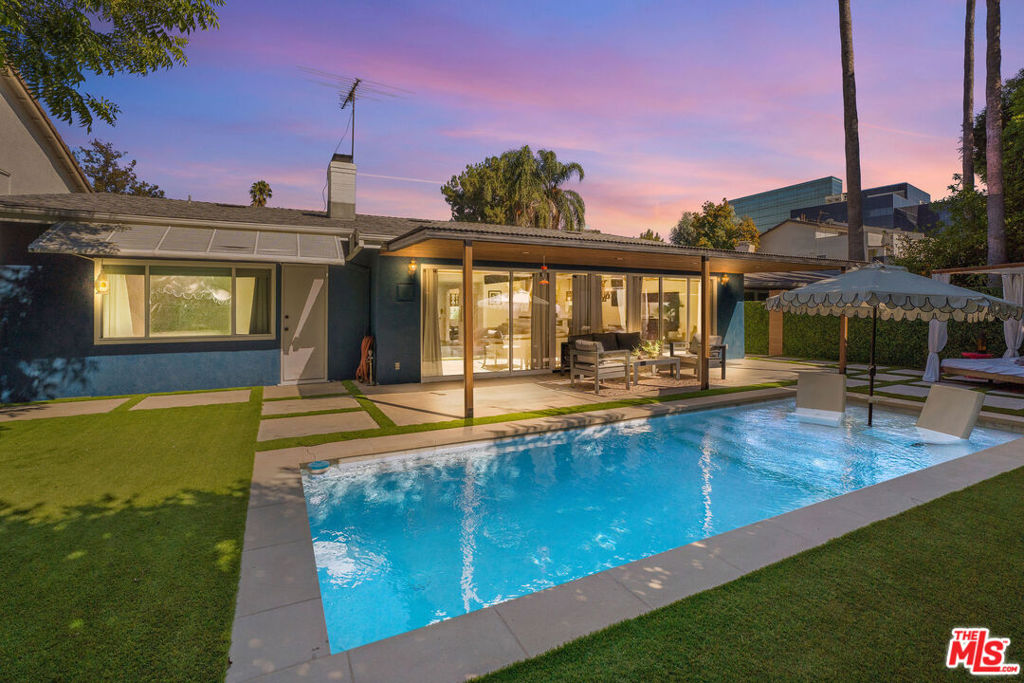 It begins the moment you turn onto a quiet cul-de-sac and pull up to a modern retreat that feels more like a private getaway. Equal parts mid-century modern and resort, it's a home designed for living beautifully. Step through the front door and you're immediately greeted by soaring vaulted ceilings and an open, sunlit space where the kitchen, dining, and living room flow together while walls of glass open to the backyard, blurring the line between indoor and out. The re-imagined kitchen is ready for both everyday cooking and lively entertaining with its newer Jenn-Air six-burner stove, KitchenAid stainless steel appliances, and generous elegant Quartz counter space. The gas-burning fireplace anchors the open living room, offering warmth and character. But the real story unfolds outside where this home shifts into full Palm Springs resort mode. The backyard was JUST completely reimagined with a new saltwater pool finished in mini-pebble and marble tile, a Baja shelf for lounging, and LED lights (must see photos!) that transform the water's mood at the push of a button for a jaw dropping evening spectacle of color. Back inside, 3 generous bedrooms, 3 baths and lots of closet space await. The primary suite overlooks the backyard retreat, a quiet perch where mornings begin with coffee and a front row view of birds and squirrels playing. Its en suite bath, fully renovated last year, combines Quartz counters and clean lines with thoughtful details, including a built-in vanity seat and spa-like shower with AKDY 52 In. 8-Jet multi-function tempered glass panel system. Luxe! Another en suite bedroom/bath with private entry and a guest room sit next to the fully remodeled common area bathroom. Behind the scenes, the upgrades are just as compelling: a new roof (2022), AC compressor (2023), plumbing overhaul (2021), attic insulation (2025), and water heater (2021) make the home ready for many years to come. Past the 2 car garage with 3 large closets, the front yard blooms with lemons, limes, roses, birds of paradise, hydrangea and aazeleas. Friendly neighbors keep an ongoing text chain looking out for each other. And while the home feels like a tucked-away escape, it's just a short walk to the ENERGY of Ventura Boulevard, with its restaurants, cafes, and shops. Quick access to the 405 and 101 makes the rest of the city just as reachable. Walk through: https://youtu.be/fnDeFtRQrAk