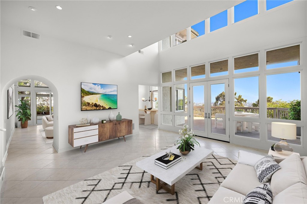 Perched in the exclusive gate-guarded enclave of Harbor Ridge, this stunning 3-bedroom, 3-bathroom residence with an additional office showcases sweeping panoramic views that stretch across the city lights, dramatic skylines, and, on clear days, the snow-capped mountains. A rare opportunity to experience refined Newport Beach living, this home blends timeless sophistication with modern comforts. Step through the private gated entry into a lush courtyard accented with brick inlay, ambient lighting, and vibrant landscaping—a serene prelude to the elegance within. The custom stained-glass double doors open to a sun-filled interior enhanced by skylights, recessed lighting, and expansive windows that capture breathtaking vistas at every turn. The main living spaces are designed for both relaxation and entertaining. The living room boasts soaring ceilings and opens seamlessly to a private patio, while the family room is anchored by a granite-framed fireplace and sliding glass doors that extend the space outdoors. The chef’s kitchen features black onyx granite countertops, an island with a warming drawer, and top-tier appliances including Sub-Zero refrigeration, Thermador ovens, Bosch dishwasher, and a four-burner Thermador gas cooktop—ideal for both everyday meals and hosting with ease. Upstairs, the office provides built-in workspaces and exceptional light. The primary suite is a private retreat with two walk-in closets, including an expansive cedar-lined dressing room, and a spa-inspired bath with dual sinks, a soaking tub, and a separate shower. French doors lead to a balcony where sweeping horizon views create the perfect backdrop for morning coffee or evening relaxation. Additional highlights include a freshly painted interior, wood flooring, dual-pane windows, a programmable climate control system, and thoughtfully upgraded finishes throughout. Residents of Harbor Ridge enjoy access to resort-style amenities including four pools and spas, three tennis courts, and picturesque walking trails. Ideally located just minutes from world-class shopping and dining at Fashion Island, the award-winning Pelican Hill Resort and Golf Course, pristine beaches, and top-rated schools, 31 Saint Tropez embodies the very best of the coastal California lifestyle.