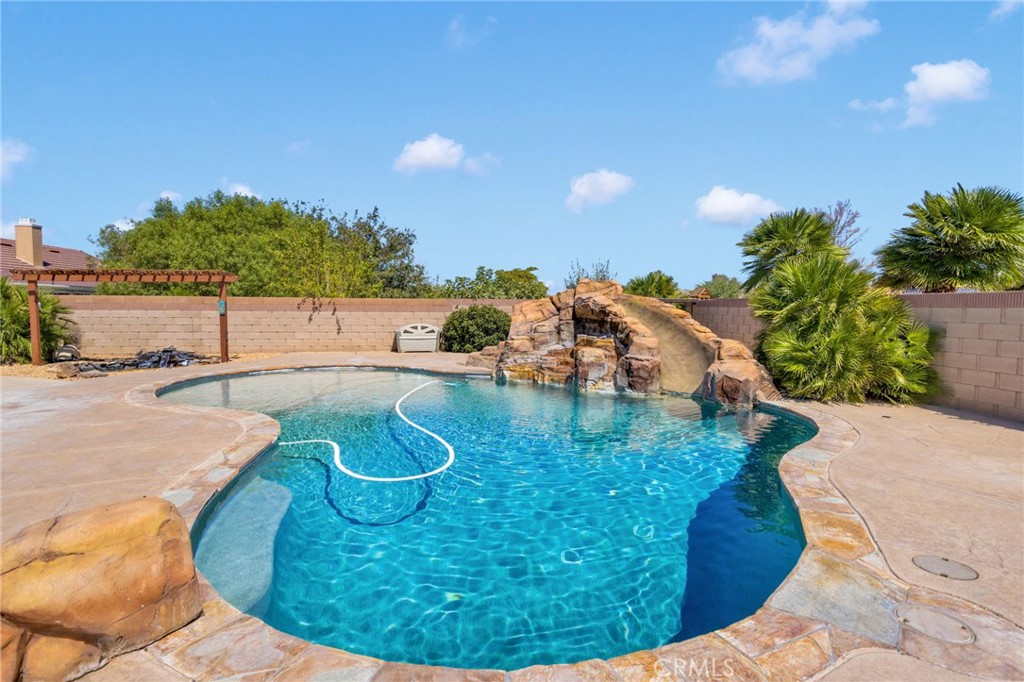 If your heart is to gather and entertain with family and friends, this home is calling your name! With 3,024 sq. ft., 5 bedrooms, and 2.5 baths, set on a spacious .45-acre lot, there is room for everyone to spread out while still staying connected. The home welcomes you with a family room featuring a woodstove insert, a versatile den/office, plus a game room with pool table and a separate bar area—perfect for fun nights of entertaining. The gourmet kitchen is the centerpiece—boasting newer stainless steel appliances, double oven, cooktop, microwave, dishwasher, and an island with power—making it a true entertainer’s dream for cooking, hosting, and memory-making.
The primary suite is a retreat of its own, complete with a bonus room ideal for a home office, nursery, or gym. The remodeled oversized bath is a showstopper with barn door entry, dual sinks, and a luxurious walk-in shower with two shower heads.
Step outside and discover your own private resort—a sparkling pool with waterfall and slide, a peaceful koi pond, green grass, and a large, extended covered patio perfect for gatherings, BBQs, and celebrations.
Additional highlights include a 14’ x 100’ RV driveway, 4-car garage, 2 large storage sheds, indoor laundry room with storage, whole house water softener, 2 HVAC units, 2 evap coolers, and paid off solar for efficiency. The front yard offers low-maintenance desert landscaping with beautiful curb appeal. There's a chicken coop if you want to be a farmer too!
Best of all, the home is close to Sitting Bull Academy and exciting new businesses, shops, and dining, giving you the perfect blend of space, convenience, and community. This is more than a house—it’s where life happens, where family and friends come together, and where the moments you treasure most are made.