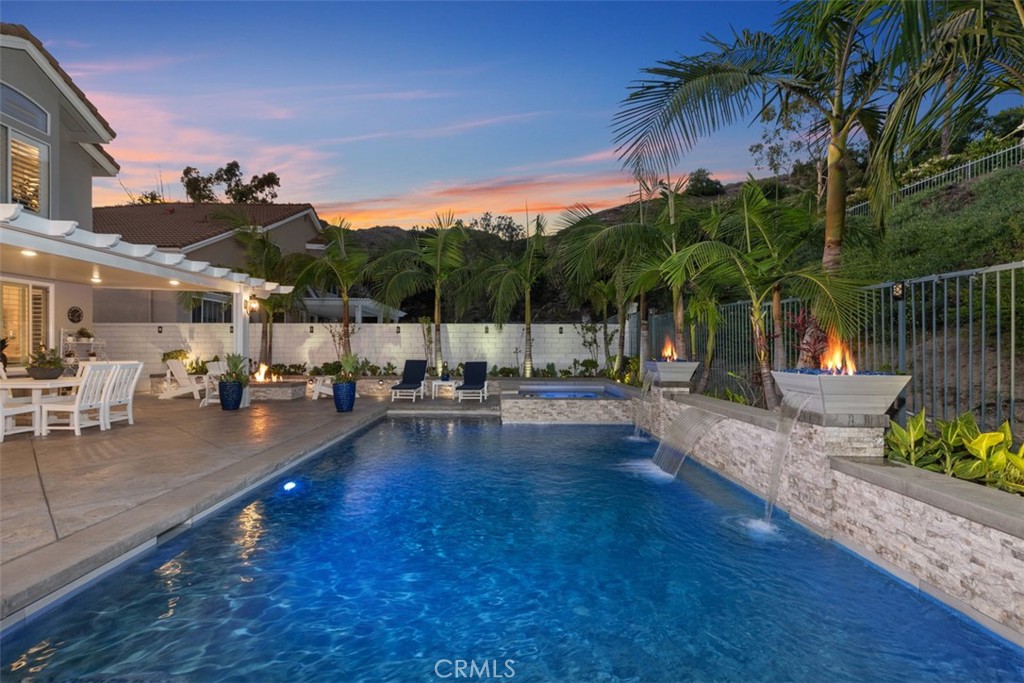 The difference is in the details, and this home has them ALL! MOVE in READY!
Unparalleled luxury in the hills of Foothill Ranch. Every feature of this home has been meticulously crafted to offer an experience like no other. This extraordinary property is a true 5-star retreat, blending sophistication, comfort, luxury and convenience at every turn.
The expansive tropical backyard is a SHOWSTOPPER! Enjoy a custom saltwater pool and spa & stunning features creating an inviting atmosphere. The large covered patio is perfect for intimate dinners & lively gatherings, while the outdoor kitchen with built-in BBQ, sink, beverage refrigerator, & bar ensures effortless hosting. Relax by the fire pit or in the thoughtfully designed conversation area.
Inside, this home is equally impressive, newly renovated with the finest finishes boasting LVP flooring, designer paint, plantation shutters & custom built-ins. The heart of the home is the newly expanded kitchen with views to the stunning oasis & opening to the family room with a cozy fireplace, the custom cabinets, quartz counters, well appointed fixtures and KitchenAid Professional appliances make cooking a pleasure. Enjoy a dedicated coffee/wine bar with custom sink & wine frig. Walk-in pantry with an abundance of storage space.
Thoughtfully designed bedrooms & bathrooms offer unparalleled comfort & style. The highly sought-after first-floor bedroom can be a private office and is conveniently close to an updated bathroom with shower. The gorgeous Primary Suite is a SANCTUARY with soaring ceilings & an expanded spa-style bathroom that includes a grand step in shower, freestanding soaking tub, two vanity areas, & a newly added walk-in closet with custom organizers. The large third & fourth bedrooms & third bathroom offer beautiful finishes. Separate interior laundry room.
Efficiency & convenience are KEY with newer: Solar system-fully owned, high-efficiency doors/windows, HVAC system & water heater.
Smart home features: Electronic door locks, automated lighting, security doorbell & camera.
A 3-car direct access garage w/automatic doors, EV power access, & an abundance of built-in cabinetry & racks for storage.
A prime community with views of magnificent sunsets, enjoy easy access to award-winning schools, parks, Whiting Ranch WP, shopping, dining, entertainment, hiking/biking, the library & nearby fwy access. Don’t miss this opportunity to own an exceptional property.