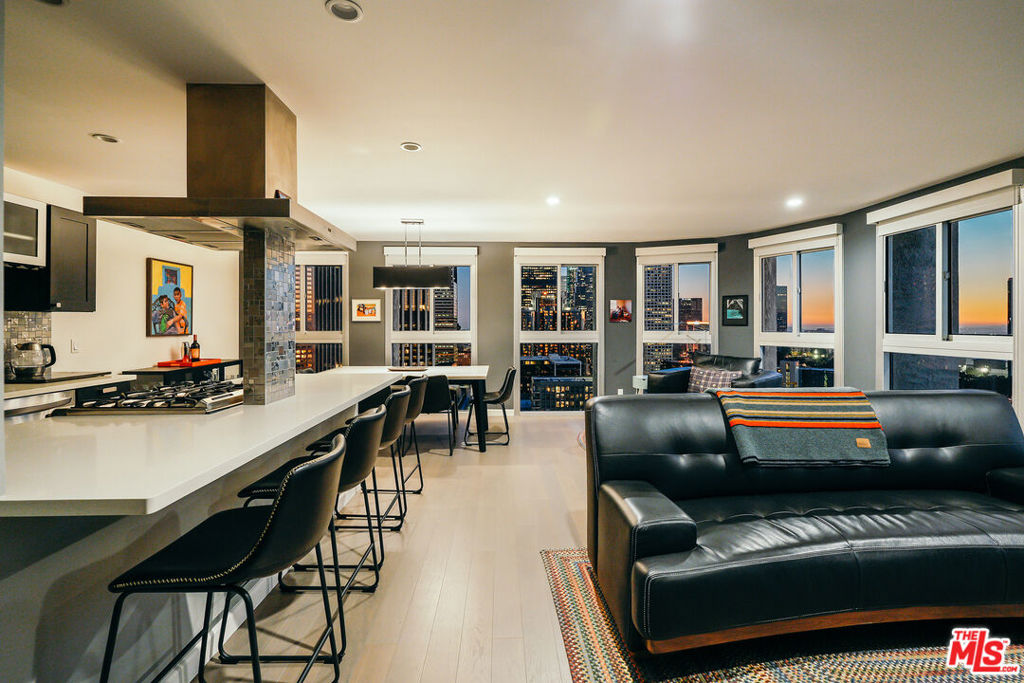 Experience this stylishly reimagined corner unit at the renowned Bunker Hill Tower, Downtown LA's premier full-service high-rise. From sweeping city lights to the Pacific Ocean, enjoy dramatic panoramic vistas that also showcase landmarks such as the Hollywood Sign and Griffith Observatory. Inside, newly installed wood flooring pairs beautifully with floor-to-ceiling double-paned windows, filling the home with natural light. Two generous bedrooms and two spa-like bathrooms reflect meticulous attention to detail. The open-concept kitchen blends sleek design with everyday functionality. Perfectly situated in the cultural hub of DTLA, you'll be just steps from the Disney Concert Hall, Music Center, Broad Museum, MOCA, and the Frank Gehry-designed Grand LA. The recently opened Grand Avenue Arts/Bunker Hill Metro Station places the entire city within easy reach. Residents of Bunker Hill Tower enjoy unmatched amenities: 24/7 concierge and security, gated guest parking, an Olympic-sized heated pool, two spas, tennis and pickleball courts, BBQ and picnic areas, playground, and two fully outfitted fitness centers. On-site conveniences include a market, beauty salon, and chiropractic office. HOA fees simplify city living by covering all essential utilities (electricity, gas, water, internet, trash, and secure parking) making this the ultimate lock-and-leave urban retreat.