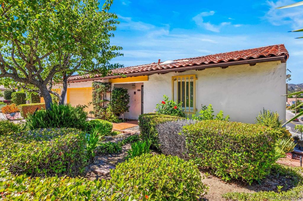 Imagine finding your own private retreat. This charming end-unit home, located in the Buena Ventura, greets you with a peaceful, gated courtyard—a perfect spot for your morning coffee. Step inside to a massive living space with vaulted ceilings that create an open, airy feel. The layout is designed for modern life, offering an exceptional opportunity for multi-generational living. A private downstairs suite features a spacious bedroom, a full bath, and not one, but two separate living areas, providing a perfect haven for family or guests. With a two-car garage, air conditioning, and dual-pane windows for energy efficiency and sound insulation, this home offers comfort and convenience in every detail. It's more than a house—it's a sanctuary waiting for you to call it home.