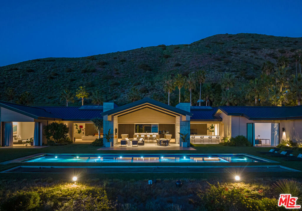 Secluded behind private gates, this one-of-a-kind Malibu estate is situated on a blufftop and surrounded by stunning ocean views. "Zero One" rests on 2.48 acres of meticulously planned grounds with over 300 trees gracing the property including native coastal oaks, and Monterey cypress and pines, as well as on-site beehives, organic fruit orchards, and vegetable gardens. Exterior grounds also provide for every type of recreation - a saltwater pool, spa, basketball court, bocce ball court, golf greens and driving range. Built from sustainable timber and recycled steel, Zero One is fully electric, featuring Tesla batteries and solar panels, resulting in zero carbon emissions. The interior consists of six bedrooms, 9 bathrooms, a theater, and gourmet chef's and main kitchen appointed with Miele appliances, induction cooktops, Caesarstone countertops, and American white oak floors. Ideal for entertaining, the great hall exemplifies indoor/outdoor living with soaring 20-foot ceilings, sliding exterior walls, expansive skylights, and two wine rooms. A full gym, water filtration system and ventilation system ensure a healthy lifestyle at all times, while water vapor fireplaces equal clean luxury. Step into the sumptuous future with Zero One.