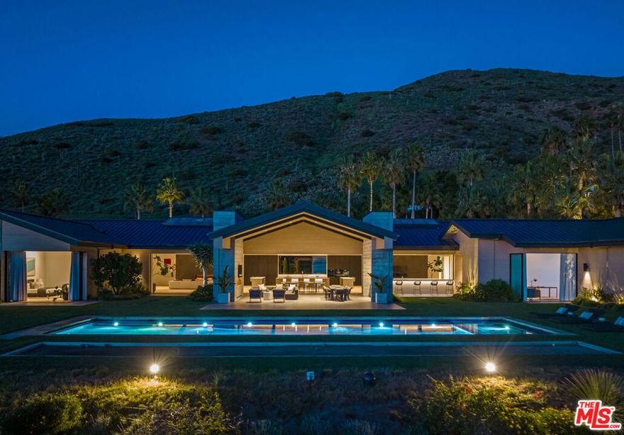Secluded behind private gates, this one-of-a-kind Malibu estate is situated on a blufftop and surrounded by stunning ocean views. "Zero One" rests on 2.48 acres of meticulously planned grounds with over 300 trees gracing the property including native coastal oaks, and Monterey cypress and pines, as well as on-site beehives, organic fruit orchards, and vegetable gardens. Exterior grounds also provide for every type of recreation - a saltwater pool, spa, basketball court, bocce ball court, golf greens and driving range. Built from sustainable timber and recycled steel, Zero One is fully electric, featuring Tesla batteries and solar panels, resulting in zero carbon emissions.  The interior consists of six bedrooms, 9 bathrooms, a theater, and gourmet chef's and main kitchen appointed with Miele appliances, induction cooktops, Caesarstone countertops, and American white oak floors. Ideal for entertaining, the great hall exemplifies indoor/outdoor living with soaring 20-foot ceilings, sliding exterior walls, expansive skylights, and two wine rooms. A full gym, water filtration system and ventilation system ensure a healthy lifestyle at all times, while water vapor fireplaces equal clean luxury. Step into the sumptuous future with Zero One.