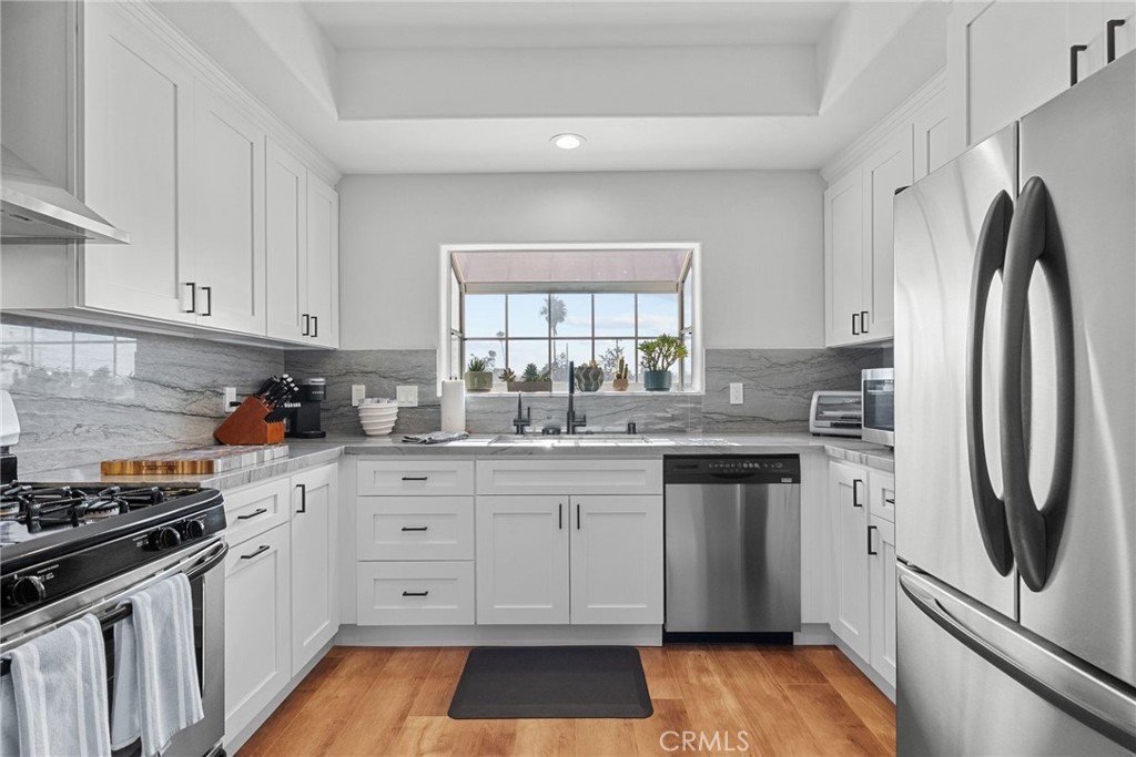 Light, spacious & stylish. This fully remodeled top-floor corner unit is flooded with natural light and offers over 1,400 sqft of living space, complete with two bedrooms with en-suite bathrooms. The upstairs primary impresses with vaulted ceilings, a large walk-in closet, and a luxuriously remodeled bathroom with ample counter space and a stunning walk-in shower. Fully renovated in 2022 with luxury vinyl plank floors, an updated kitchen with quartzite countertops, modern bathrooms, plus upgrades including HVAC (2025), tankless water heater (2022), and a new sliding glass door (2023). With convenience in mind, a stackable washer/dryer can be found between the two bedrooms. Plenty of storage, open-concept living/dining, a guest powder room, and two tandem parking spaces provide comfort and functionality. Located near the heart of Toluca Lake with walkable dining and shopping, this tastefully remodeled unit is the perfect place to call home.