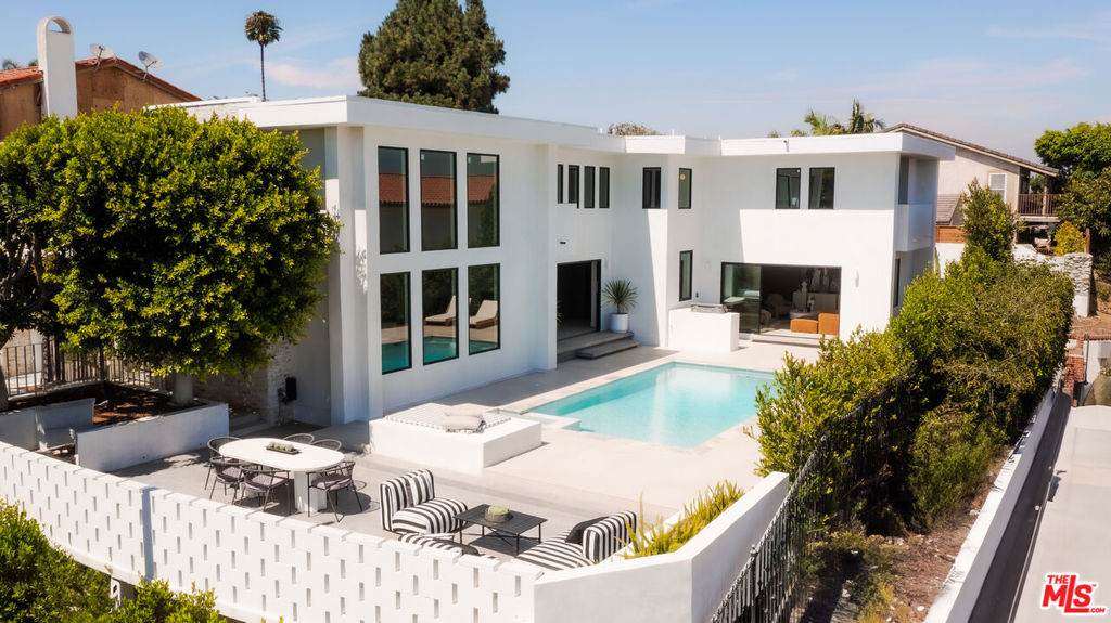 Thoughtfully reimagined by Devall Design Home, this stunning five-bedroom, five-bathroom residence offers timeless style, natural light, and seamless indoor-outdoor living in the heart of the Hollywood Hills. Every detail has been curated with intention, from the uniquely designed architectural features to the expansive views spanning from Downtown to Catalina Island. The home's open layout is ideal for entertaining, with multiple living spaces, including one centered around a living tree that brings a touch of nature indoors. A dramatic curved staircase anchors the main living area, complemented by a custom-built bar and designer lighting. The oversized pool, outdoor kitchen, and fireplace create an effortless extension of the interior spaces. The chef's kitchen is outfitted with a full suite of Miele appliances, a built-in coffee bar and is the heart of the home. Sleek floor-to-ceiling Fleetwood windows and doors flood the home with light. Three of the five oversized bedrooms feature en-suite bathrooms and private outdoor areas. Located just moments from the iconic Sunset Strip and set within a secure community with 24/7 neighborhood patrol, this home offers both tranquility and easy access to dining, entertainment, and culture. A true reflection of the lifestyle in the Hollywood Hills.