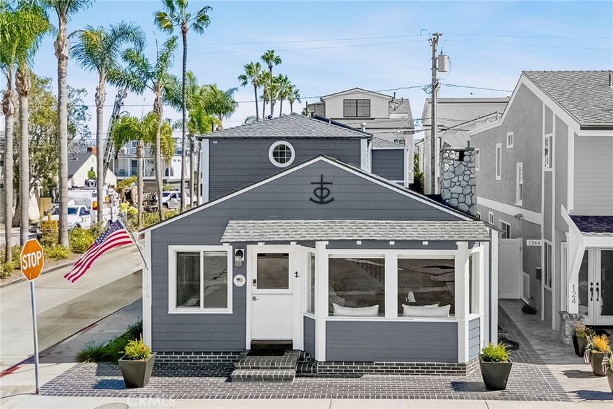 Stunning Balboa Island home perched on a sunny corner, just one block from the South Bayfront. Enter through a Dutch door into the expansive open concept living/dining area. The bright and airy atmosphere is accentuated by 2-story beamed ceilings and a bay window with built-in seating. The deluxe kitchen is a chef’s delight with quartz and marble counters and top-quality appliances including a Bertazzoni range. This level of the home also presents a rare first-floor bedroom, along with a 3/4 bath, 2-car garage, and brick-lined side patio running the entire length of the house. The second level showcases an awesome primary suite with gigantic spa-quality bath, sizable closet, and separate sitting room. Completing the upstairs is a guest bedroom with full bath. Additional amenities of this exceptional home blend nautical charm with modern convenience including central A/C, stone tile floors, beamed ceilings on both levels, and first-rate finishes throughout.