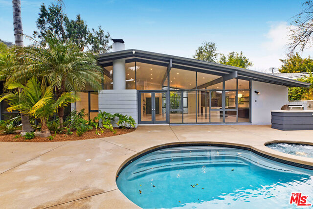 Designed by renowned architect Ed Fickett, this meticulously redone mid-century post-and-beam home is available for lease in the coveted Nichols Canyon "Colony." Featuring 4 bedrooms and 3 bathrooms, the residence offers a circular drive, terrazzo floors, and a chef's kitchen with island open to a spacious great room with vaulted ceilings and walls of glass. The lush, tropical setting includes large patios, a built-in BBQ, and a renovated pool and spa, creating the perfect backdrop for private, resort-style living. A special architectural gem!