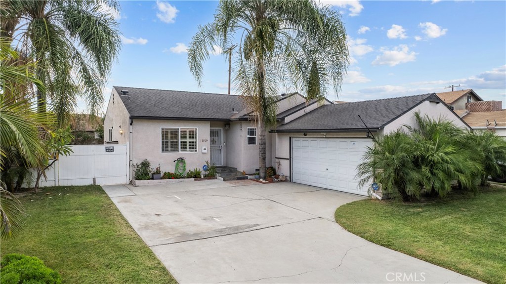 Beautifully Updated Corner-Lot Home with Outdoor Entertaining Space! Move-in ready and upgraded, this stylish 3-bedroom, 2-bath home sits on a spacious corner lot with possible RV access and fantastic curb appeal. Palm trees, dual pane windows, and custom exterior finishes set the tone before you even step inside. The interior features laminate flooring, plantation shutters, recessed lighting, and custom paint with detailed crown molding and baseboards that create a warm and polished atmosphere throughout. The remodeled kitchen is a Standout! Showcasing rich cherrywood cabinets, granite countertops, stainless steel appliances including a wine fridge, tile flooring, and a large pantry with plenty of storage. Both bathrooms have been tastefully updated. The hall bath features a newer vanity, tile shower, and matching tile floors, while the primary suite offers an upgraded tile shower, updated vanity, and a walk-in closet for added convenience. All three bedrooms are generous in size and offer flexibility for family living, guests, or a home office. The outdoor space is ideal for relaxing or entertaining, featuring a newer covered patio with recessed lighting and pavers that create a comfortable, finished area for dining or lounging. The corner lot provides added privacy and room to grow, along with the benefit of potential RV access. With modern upgrades, inviting finishes, and a prime location, this Norwalk gem offers the California lifestyle at its best!