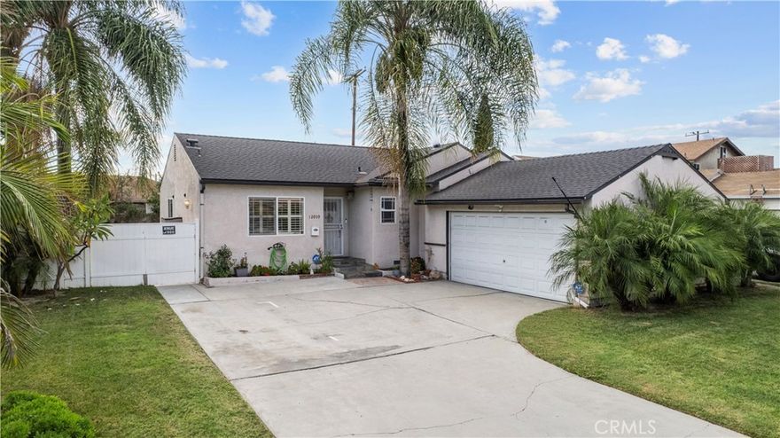 Beautifully Updated Corner-Lot Home with Outdoor Entertaining Space!  Move-in ready and upgraded, this stylish 3-bedroom, 2-bath home sits on a spacious corner lot with possible RV access and fantastic curb appeal. Palm trees, dual pane windows, and custom exterior finishes set the tone before you even step inside. The interior features laminate flooring, plantation shutters, recessed lighting, and custom paint with detailed crown molding and baseboards that create a warm and polished atmosphere throughout.  The remodeled kitchen is a Standout! Showcasing rich cherrywood cabinets, granite countertops, stainless steel appliances including a wine fridge, tile flooring, and a large pantry with plenty of storage. Both bathrooms have been tastefully updated. The hall bath features a newer vanity, tile shower, and matching tile floors, while the primary suite offers an upgraded tile shower, updated vanity, and a walk-in closet for added convenience.  All three bedrooms are generous in size and offer flexibility for family living, guests, or a home office. The outdoor space is ideal for relaxing or entertaining, featuring a newer covered patio with recessed lighting and pavers that create a comfortable, finished area for dining or lounging. The corner lot provides added privacy and room to grow, along with the benefit of potential RV access.  With modern upgrades, inviting finishes, and a prime location, this Norwalk gem offers the California lifestyle at its best!