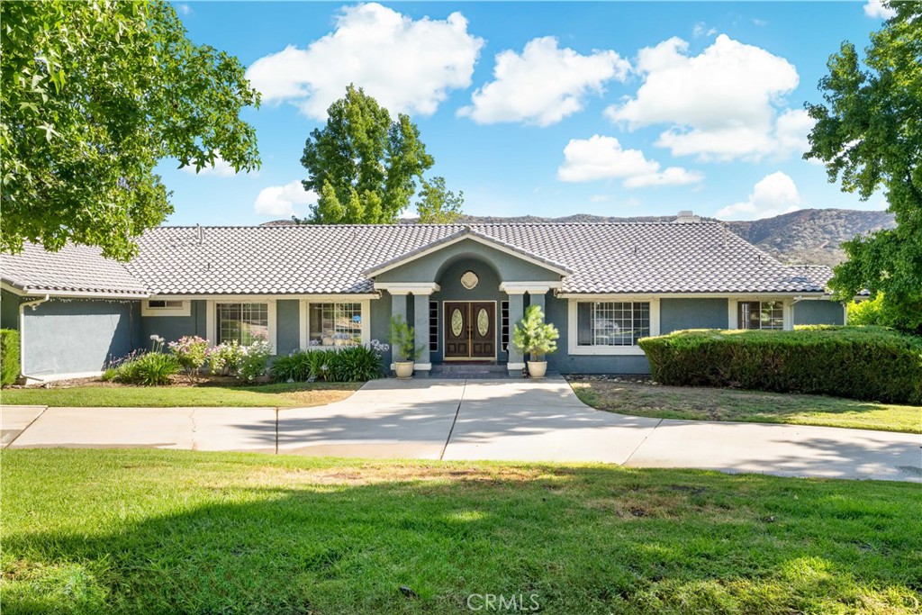This beautifully designed single-story custom home is located in the highly sought-after Hidden Meadows community of Yucaipa. With approximately 3,586 square feet of living space on a spacious 0.63-acre lot, the home offers an open and airy layout with soaring vaulted ceilings and abundant natural light, creating a warm and elegant atmosphere.
The open-concept kitchen features a large granite center island, ample cabinetry, a walk-in pantry, and a cozy breakfast nook. It flows seamlessly into the expansive formal dining room and family room, making the layout ideal for both everyday living and entertaining.
The home includes four bedrooms, two of which are en-suite. The primary suite features a private view deck and a large attached office, which can also serve as a fifth bedroom or nursery. The luxurious primary bathroom offers a jetted tub, a walk-in shower, and dual vanities. A separate laundry room and generous storage space throughout the home add to its functionality.
The oversized 3.5-car garage includes built-in cabinets and offers direct access to the kitchen. Outside, the property includes a gated RV parking area with water and electrical hookups, a spacious brick patio with a pergola and outdoor fireplace, and a beautifully landscaped backyard.
The garden is filled with mature rose bushes and a variety of fruit trees, including apple, cherry, peach, plum, and apricot, as well as blackberry, red raspberry, and white raspberry bushes—offering year-round enjoyment and harvest. The backyard offers unobstructed mountain views and exceptional privacy.
Located in a quiet and well-maintained neighborhood with convenient access to schools, parks, and major highways, this home is a rare opportunity to enjoy comfort, functionality, and timeless beauty in one of Yucaipa’s premier communities.