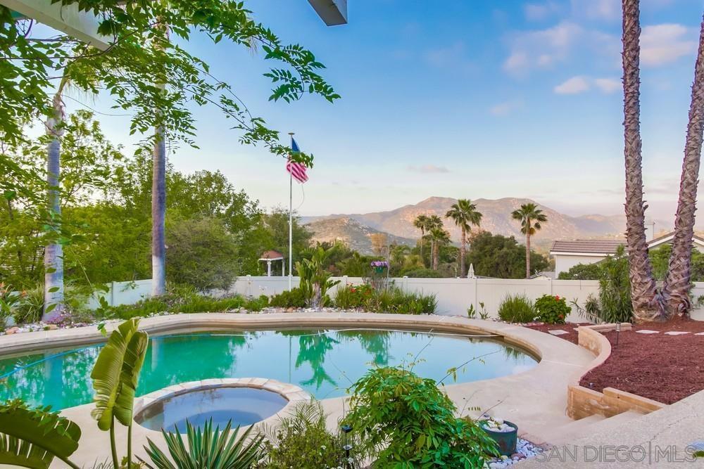 Welcome to this beautiful country home nestled above the golf course in the San Diego Country Estates! Offering PAID solar, incredible mountain views, sparkling pool/spa & a true indoor-outdoor lifestyle. Step through the double front doors into a warm, light-filled interior w/ wood floors, formal living & dining area, high ceilings, cozy fireplace, & wet bar—perfect for entertaining. Large windows frame breathtaking scenery, while the open layout creates an inviting atmosphere. The spacious kitchen boasts ample cabinetry, a garden window w/ b-fast nook. Sliding patio doors into your private backyard retreat, complete w/ shaded pergolas, mature trees, pool, outdoor BBQ & plenty of room to relax & entertain. A workshop & 2 sheds inside the fenced property. The generous Master suite is a peaceful haven, featuring tile, large bay window, direct patio access, an en-suite bath w/ dual closets & sinks, soaking tub, separate shower, & a private water closet. 2 additional bedrooms share a full bath, & there's a bonus room—perfect for a home office—w/ built-in storage. This home comes w/ a full laundry room w/ hookups, 220 outlet, a half bath near kitchen, 3-car garage, & wide driveway w/ space for multiple vehicles. As part of the San Diego Country Estates community, you'll enjoy resort-style amenities such as an award-winning golf course, 2 equestrian centers, dining & event venues, & a network of trails ideal for hiking, biking, & horseback riding to enjoy the upscale country living!