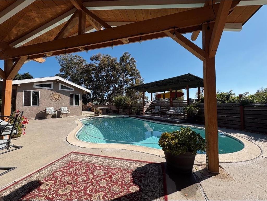 Spacious 5-Bedroom 4-Bath home with junior ADU, pool, and expansive backyard retreat offering approximately 2,000 sq ft of comfortable living space, this versatile home includes an attached Junior ADU—ideal for rental income, guest quarters, or multigenerational living. The open and airy main living area and primary suite feature vaulted ceilings, creating a bright and inviting atmosphere. Step outside to your own private oasis. The backyard is designed for entertaining and relaxation with a sparkling pool, lush landscaping, and a tranquil "private jungle" that backs up to a scenic greenbelt. With nearly half an acre of outdoor space, the possibilities are endless. Bring your vision and personal touch to make this unique property truly your own. Hang Loose Here!
