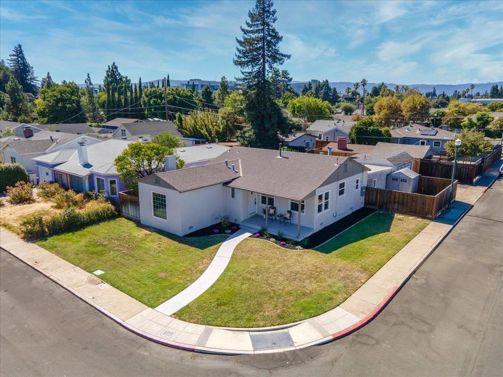 This charming 1930's Mediterranean style home sits on a large corner lot. Spacious living room with original tiled fireplace & large picture window. Formal dining room with a darling built-in cabinet. Country kitchen with newer dishwasher, sink, faucet, gas oven/range, disposal, tile floor and breakfast nook. Inside laundry with gas/electric. Built-in Ironing board . Three spacious bedrooms one with built-in shelves. Hardwood floors throughout. Updated bathroom with separate tiled stall shower, tub and tile floor. Newer light fixtures and hardware. Recessed lights. Double pane windows. Newer forced air heating. Freshly painted interior & exterior. Updated 200 AMP electrical panel. Detached 2 car garage with newer door and opener. Very large lot with many expansion possibilities including a possible ADU. Newer fencing. Plenty of parking for extra vehicles. Updated and mature landscaping. Cozy front porch. Close to Westfield Mall, Santana Row, San Jose Mineta Airport, downtown San Jose, Light Rail & Caltrain