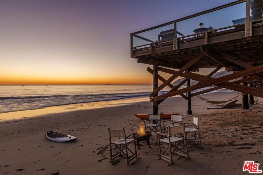 Malibu coastal lifestyle with nearly 70 feet of sandy shoreline.  This 3-bedroom, 2-bath beach house sits directly on the sand with uninterrupted ocean access.  The primary suite faces the water, joined by two guest bedrooms, and opens to an expansive beachfront deck.  The deck provides space for dining, lounging, and outdoor entertaining with panoramic views from Catalina to the Channel Islands.  Private stairs lead to the sand for any water sport from family fun like paddle boarding, kayaking, boogie boarding, and snorkeling to pursuits for more extreme athletes such as surfing, kite surfing, spear fishing, and open-water boating.  A hot-water shower at beach level adds convenience after time in the ocean.  Sea life including dolphins, whales (seasonal), sea lions, and seabirds is seen almost daily, adding to the natural setting.  The home's location combines direct beachfront living with nearby amenities. Scenic hiking trails are close by in the Santa Monica Mountains.  Neptune's Net Restaurant offers fresh seafood is a quick stroll, while both Trancas Country Market and Pt. Dume are only minutes away with additional shopping and restaurants.  Experience Malibu beachfront living at its finest - where the sand is your backyard, the ocean your playground, and sunsets sweep the sky with magical color year-round, framing the beauty of the coast.