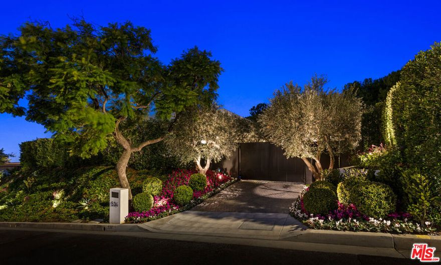 World class gated Trousdale Estates compound with unparalleled scale, timeless elegance and explosive city and ocean views. Euroline steel case French doors welcome you to ~6,200sf of stunning and sophisticated custom details and finishes throughout the 5 bedrooms and 7 bathrooms. Refined with imposing chevron French Oak floors, floor to ceiling Euroline steel case windows and doors that radiate bright natural light throughout, Longhi door handles, Delta and apparatus lighting, hand sewn and hemmed European draperies throughout, and a gourmet Dada kitchen with top-of-the-line appliances. Down an elongated hallway, the spacious primary suite is complete with built-in shelving, a sitting area that has direct access to your backyard, as well as his and her spa-like bathrooms with dual Molteni vanities and closets. Additional amenities and features in this one-level compound include: a home theater, fitness center, sitting room with gorgeous bronze-built wet bar, designer wine cellar, and a nationally recognized glass blowing sculpture in Skylight called "Galaxy" by David Gappa, designed specifically for this property, and includes 400 individually blown glass orbs with clear, frosted and opalescent glazes. Offering LA's finest indoor/outdoor experience, the home brings the outdoors in with doors throughout that lead you to an amazing outdoor area that features a large patio for entertaining, green space, Lautner edge pool, fire pit, and jetliner views. Property is being offered as is with furniture included! Perfect opportunity for the most discerning buyer to move into this dream home with ease!