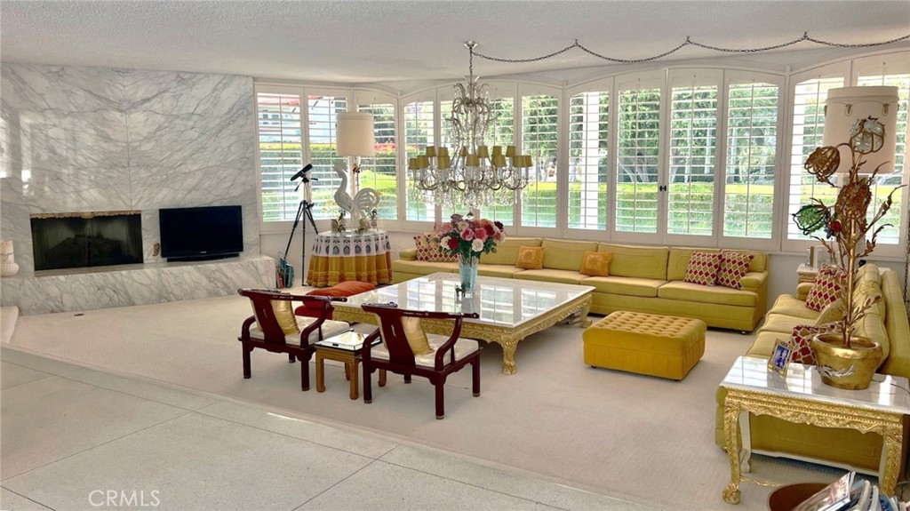 Step into a time capsule of mid-century modern perfection in the heart of Palm Springs! Designed by renowned architect John Outcalt, this 1965 gem blends retro sophistication with seamless indoor-outdoor living. Just three blocks from downtown in the coveted Historic Tennis Club district, it offers stunning views of the San Jacinto Mountains. Beyond the double-door entry, an extra-large sunken living room welcomes you with a dramatic floor-to-ceiling marble fireplace, higher ceilings, and walls of glass. Original terrazzo flooring leads to the dining area, perfectly positioned next to a fabulous vintage wet bar. The adjacent kitchen features a walk-in pantry and a separate laundry area. Two oversized primary suites offer vintage luxury with terrazzo-clad baths, sunken tubs, and private patios. A third bedroom—ideal as a media room or guest retreat—includes twin beds, a desk area, and its own terrazzo shower/tub combo. Sliding glass doors in every bedroom open to the sun-drenched pool deck, where a sparkling pool, lounge space, and breathtaking mountain views create a dreamy retreat. Private patios, an attached two-car garage, 3 cabanas and an unbeatable location near top restaurants, the Agua Caliente spa, Palm Springs Art Museum, and the famous Thursday night street fair complete this timeless escape. Select furnishings are available for purchase to keep the vintage vibes alive.