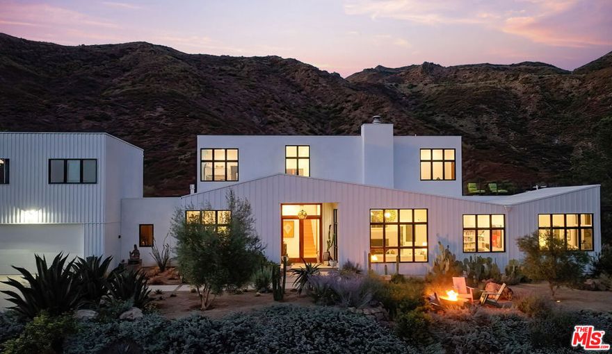 Where Privacy Meets Personality!  A Modern Masterpiece Surrounded by Nature.  Ever dream of a home where the only thing you hear at night is the sound of the breeze and maybe an owl?   Where you can throw open your windows, see acres of your own land, and feel completely removed from the world (but still live in close proximity to all amenities)?  Welcome to your modern escape,  a newly built architectural showpiece that's equal parts luxury, design, and California cool. Created by ERW Design out of the Yale School of Architecture, this home is a masterclass in how bold modern design and nature can live in perfect harmony.  From the moment you walk in, it's a full sensory experience. The grand entry opens to a 14-foot ceiling great room wrapped in glass, so every view looks like a painting. The custom Arto tile wood burning fireplace anchors the space stylish enough for cocktails, cozy enough for movie nights and even a built-in reading nook that whispers "curl up with a book and stay awhile.  The chef's kitchen is pure inspiration.  Fireclay wall tiles from San Francisco, handcrafted walnut cabinetry, a wine fridge (of course), and mid-century Dutch pendants that make even morning coffee feel glamorous. There's a walk-in pantry for the organized, and room for everyone to hang out and cook together.  Just off the kitchen, the den is your new happy place  with a gas fireplace, lush garden views, and even a built-in office space across from the separate laundry room.    The primary suite?   Think spa-meets-sanctuary. Porcelanosa vanities, Moroccan zellige tiles, custom walnut cabinetry, and a soaking tub with front-row mountain views. Seasonal waterfalls in sight, natural light pouring in,   it's impossible not to exhale and it's on the first floor. Sustainability was never an afterthought here. Bamboo flooring downstairs, cork upstairs, solar panels, backup batteries, and an EV charger mean your home is as smart as it is beautiful.  Step outside and it only gets better,  a landscape that feels alive. Pepper trees, jacarandas, vegetable gardens, and a lime tree thrive under an automated watering system, while seasonal springs and waterfalls at the back of the property bring a dose of pure serenity.  Room for pool, tennis court, horses.   Three additional en suite bedrooms upstairs with an expansive deck overlooks the entire property.  Need space for guests or a little separation? The private guesthouse (not pictured) offers a full bedroom, kitchen, and bath  perfect for friends, family, or a creative studio.  This isn't just a house,  it's a lifestyle.   A home that's peaceful but powerful, elegant but playful, private yet welcoming. Designed for those who want modern design, a connection to nature, and just a hint of magic in their everyday life.  Main House: 3,253 sq ft | Guest House: 458 sq ft | Garage: 458 sq ft.   3 acres.  Available Furnished