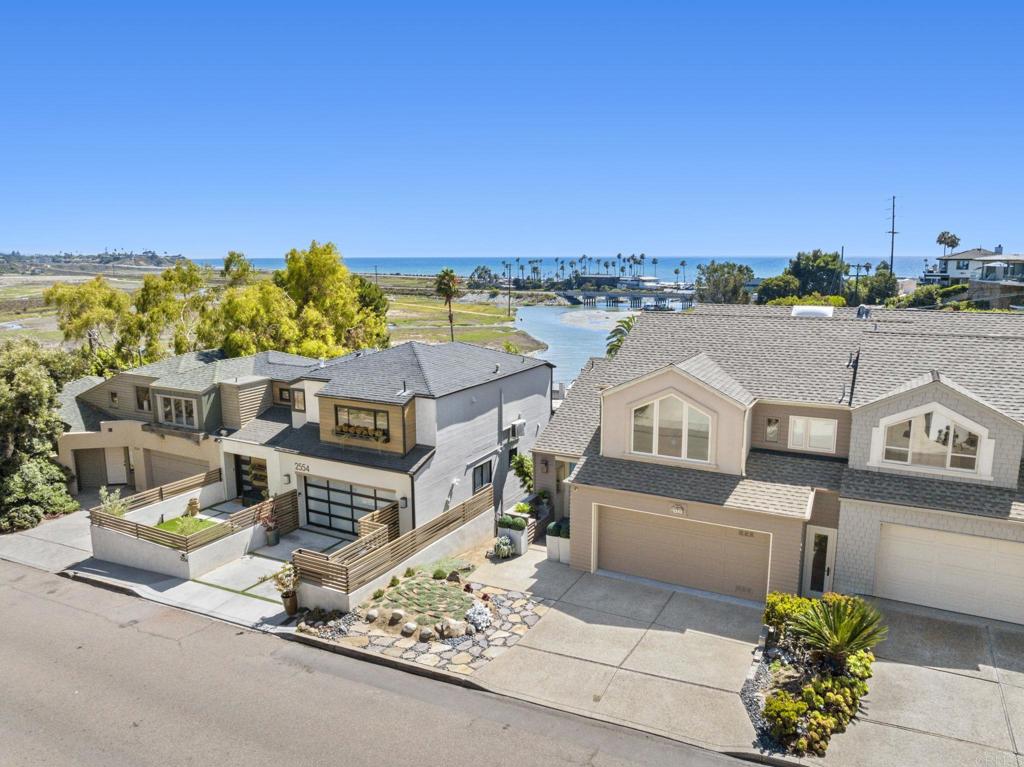 Welcome to 2542 Manchester—a beautifully updated coastal Cardiff twinhome offering breathtaking white water ocean views and exceptional versatility, just moments from the beach. Perched to capture stunning vistas of the ocean and San Elijo Lagoon, this light-filled home is perfectly positioned for enjoying the best of coastal living. The flexible floor plan includes a private lower-level suite with its own separate entrance—ideal for a lock-off rental, guest quarters, or multi-generational living. Whether you're looking for passive income, space for extended family, or a private home office, this area offers privacy and potential. Upstairs, the open-concept main living area showcases cathedral ceilings, expansive windows, updated finishes, and effortless flow to outdoor deck—perfect for taking in sunsets and ocean breezes. The updated kitchen and sunlit living areas make everyday living and entertaining a joy. Enjoy the privacy and feel of a single-family home in this rare two-unit condo, where the only shared wall is with one other owner-occupied residence. Enjoy walkability to the lagoon trail, beach, and vibrant local village—everything from boutique shopping and cafes to scenic nature walks and legendary surfing just minutes from your front door. With its incredible views, lock-off potential, and prime location, 2542 Manchester is the lifestyle opportunity you’ve been waiting for.